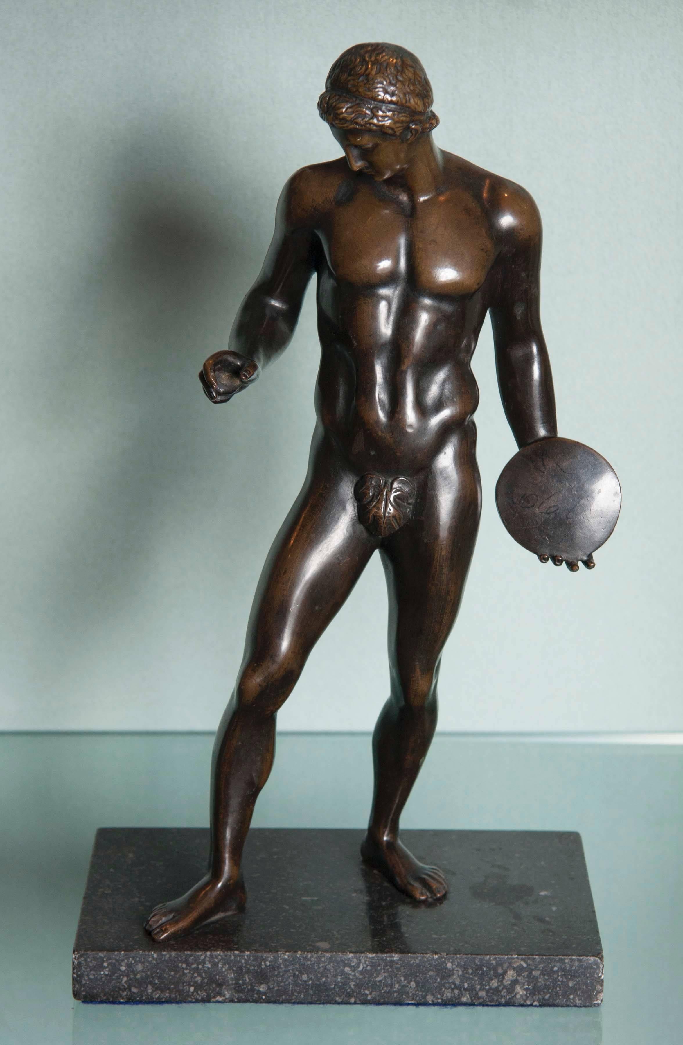 A Grand Tour patinated bronze figure of a discus thrower.