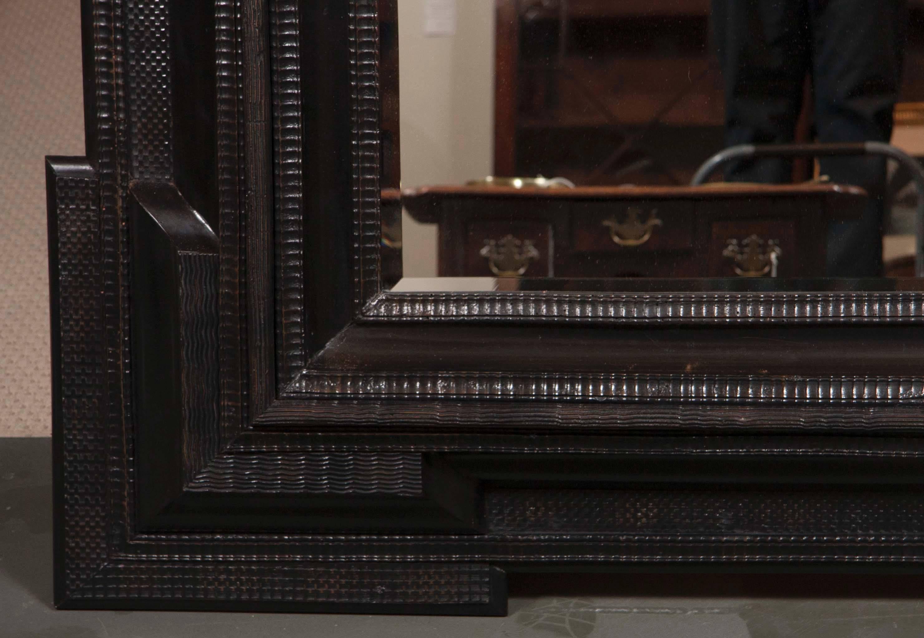 A Monumental 19th century Dutch ebonized black crossetted corner framed mirror with new beveled glass plate.

