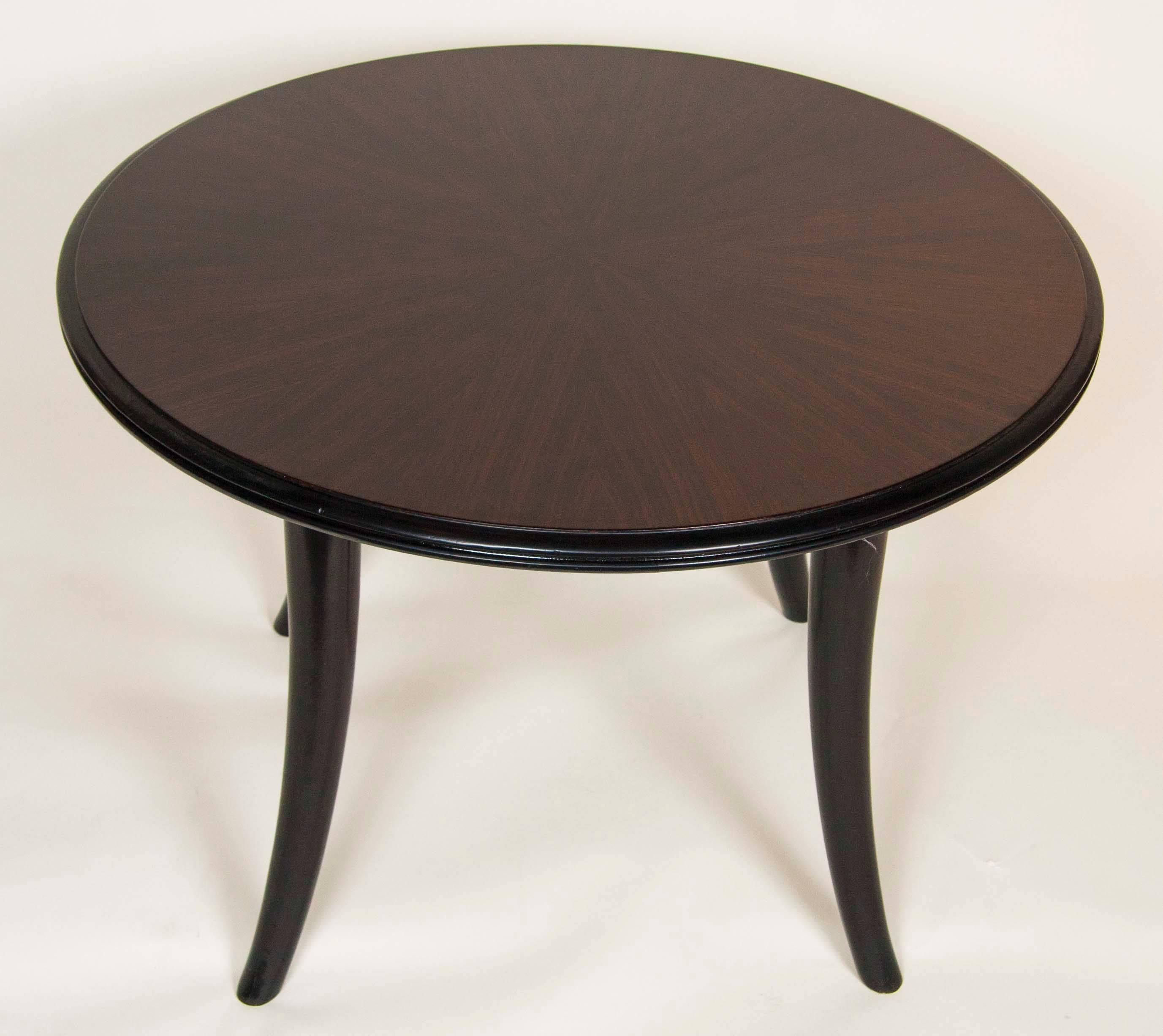 An Art Deco part ebonized round side table of zebrawood with sabre legs.