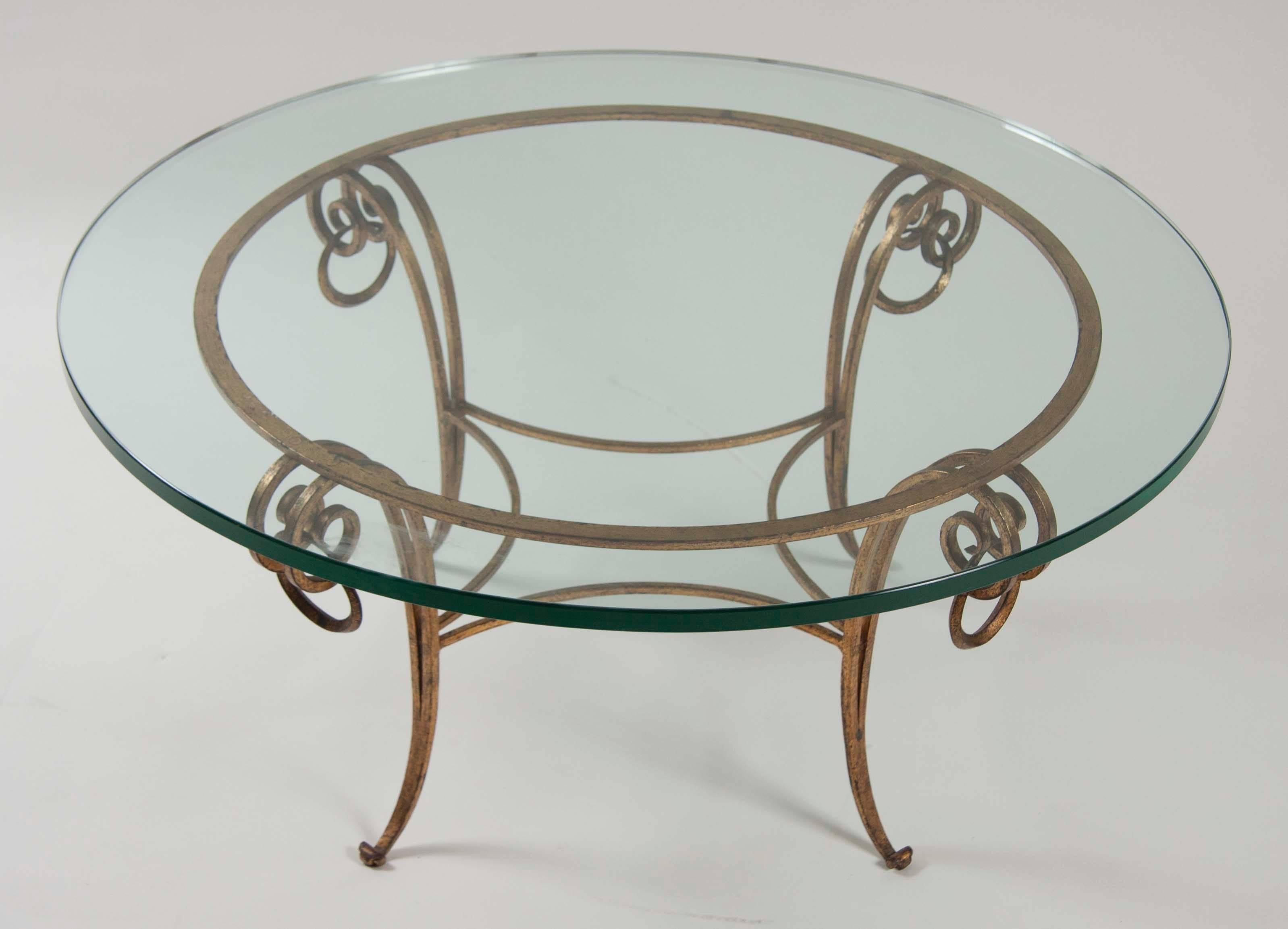 A gilt iron glass top coffee table in the manner of Rene Drouet, French.