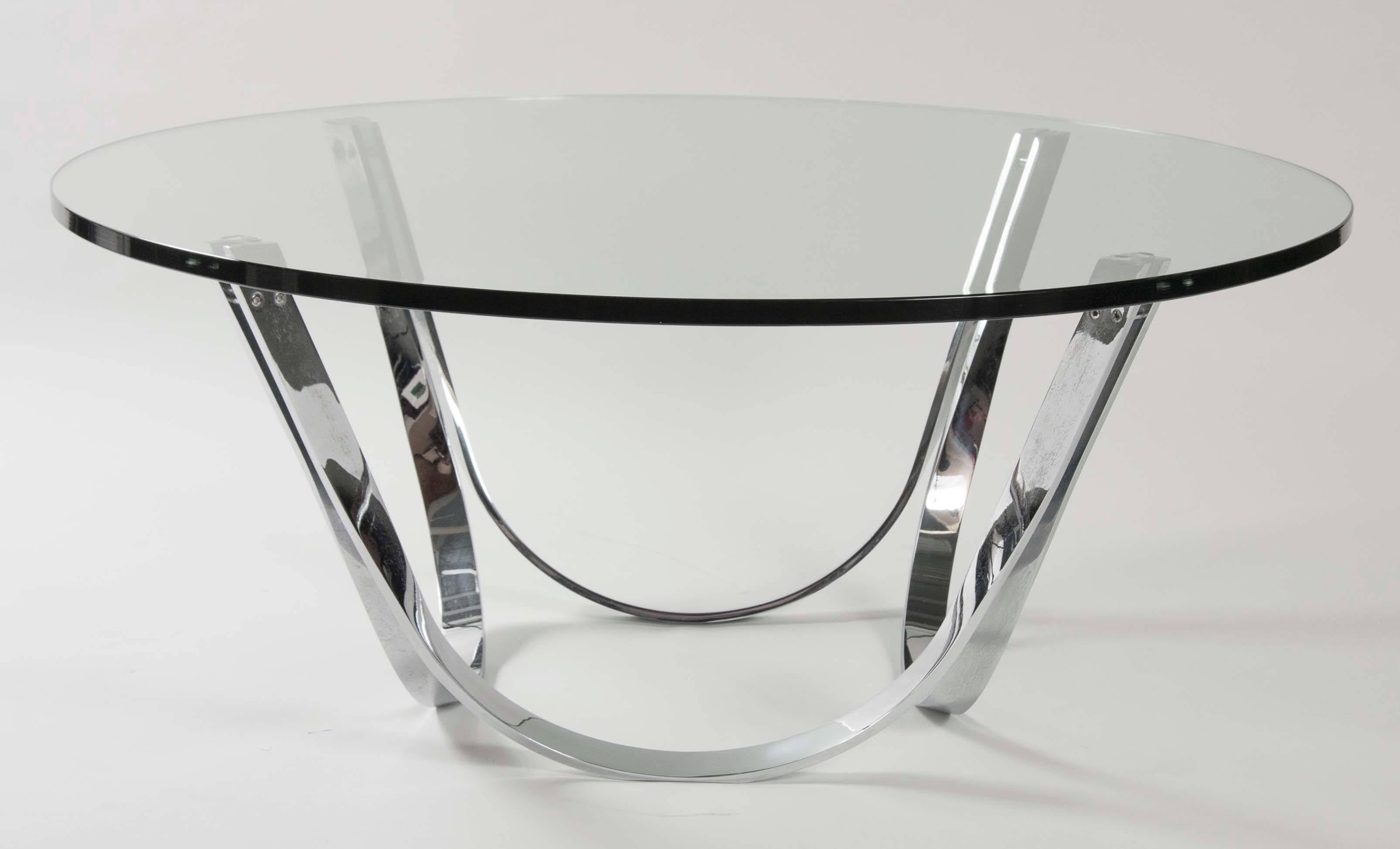 An elegant polished aluminum coffee table by Tri-Mark Designs with a tempered round glass top.