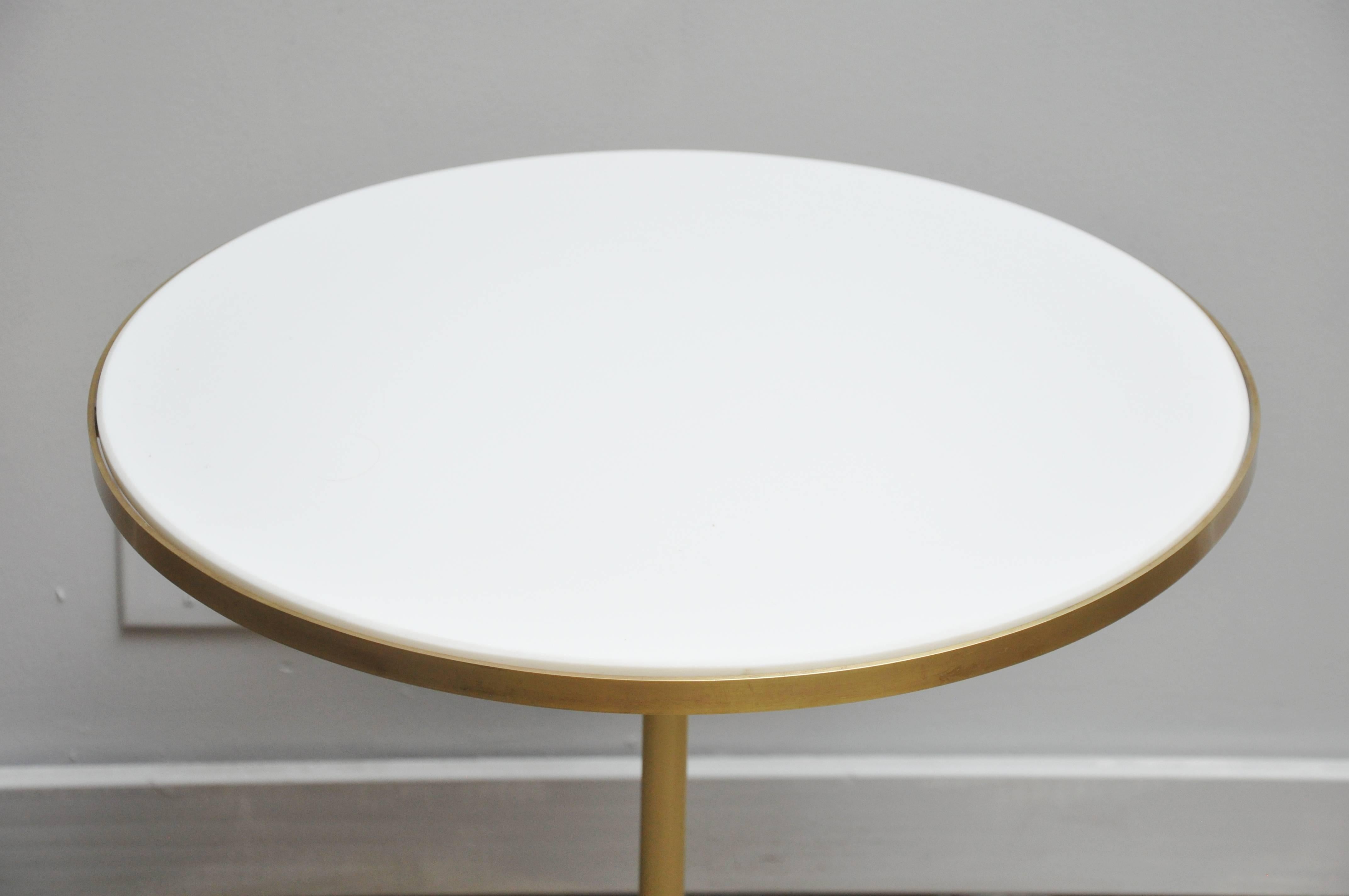 Paul McCobb brass tripod pedestal side tables with white vitrolite glass tops.