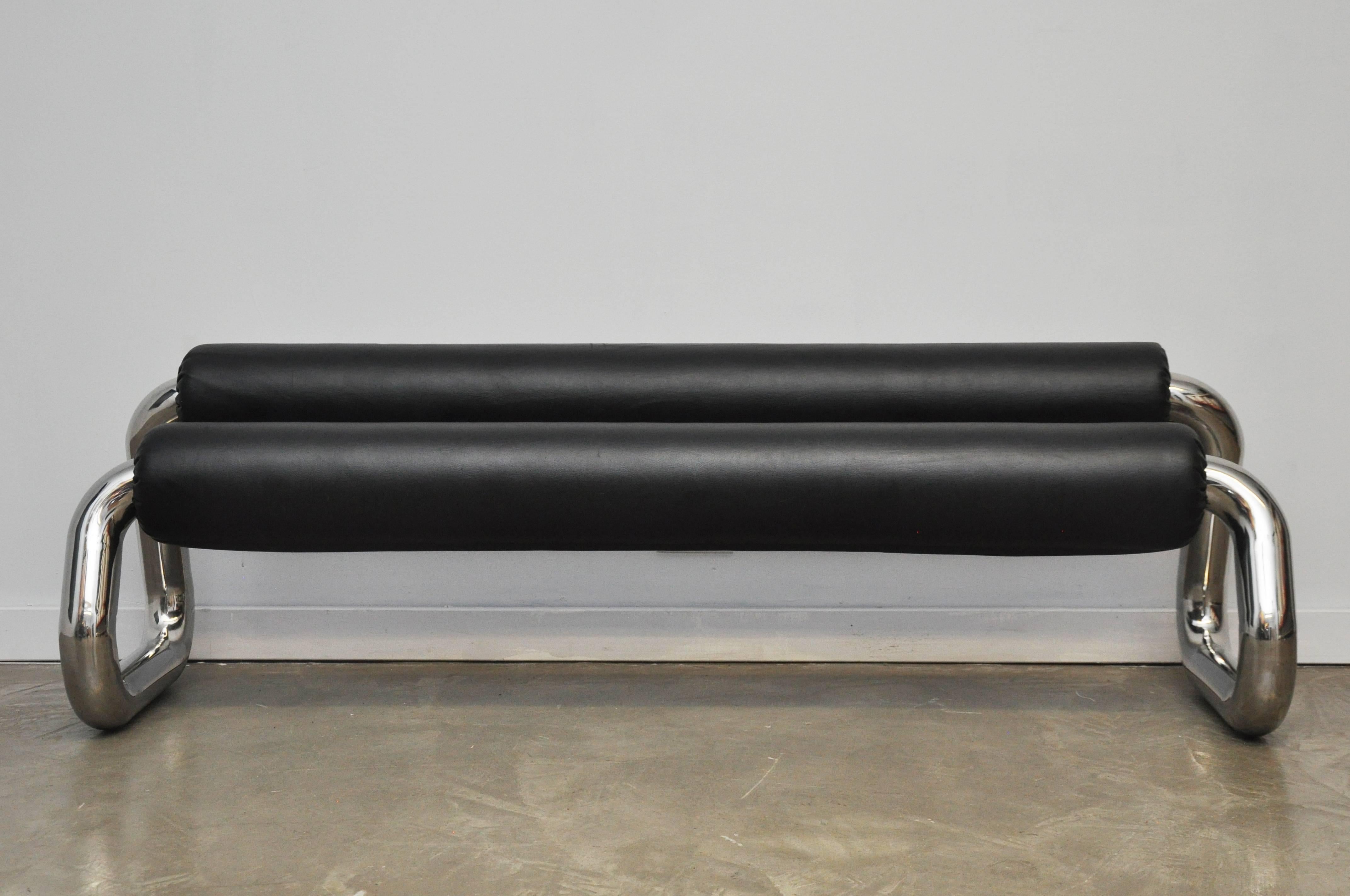 Thick stainless steel tubular bench, circa 1970s. Sculptural form with raised backrest.