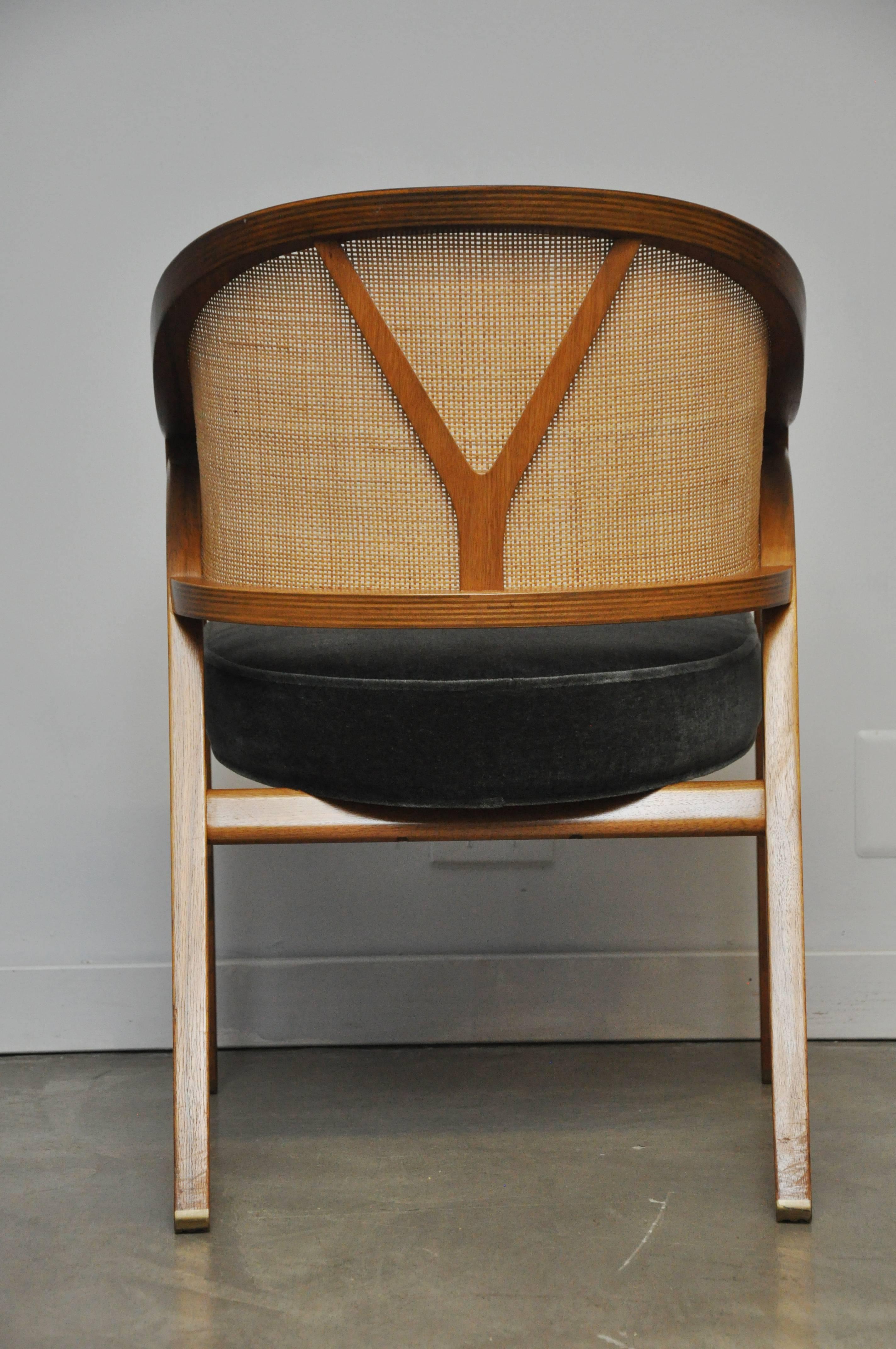 Walnut frame captain chair by Edward Wormley. Cane back with new mohair upholstery.