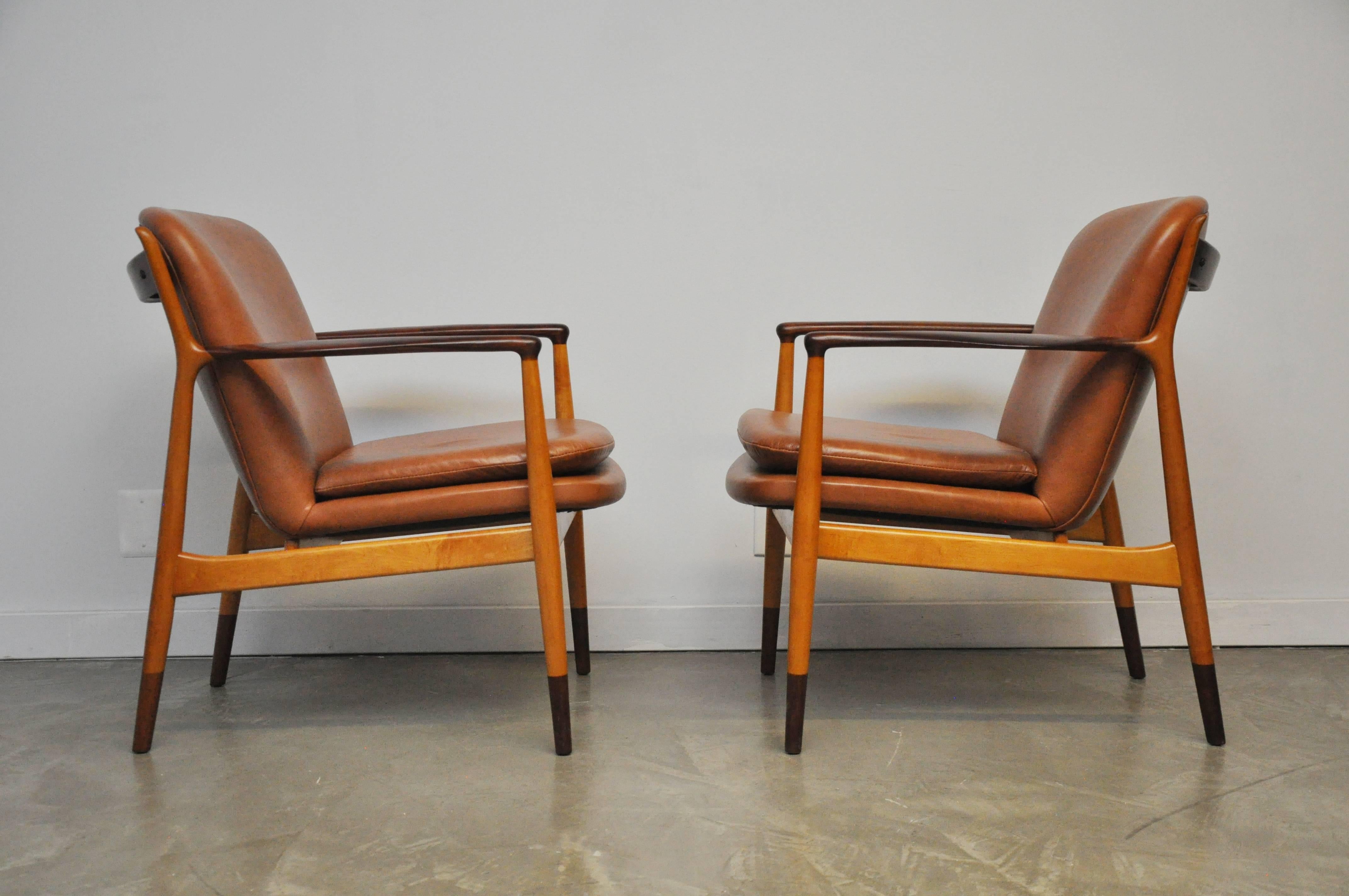 Beautiful pair of delegate lounge chairs by Finn Juhl. Rare combination of birch and walnut frames, fully restored. New leather upholstery.