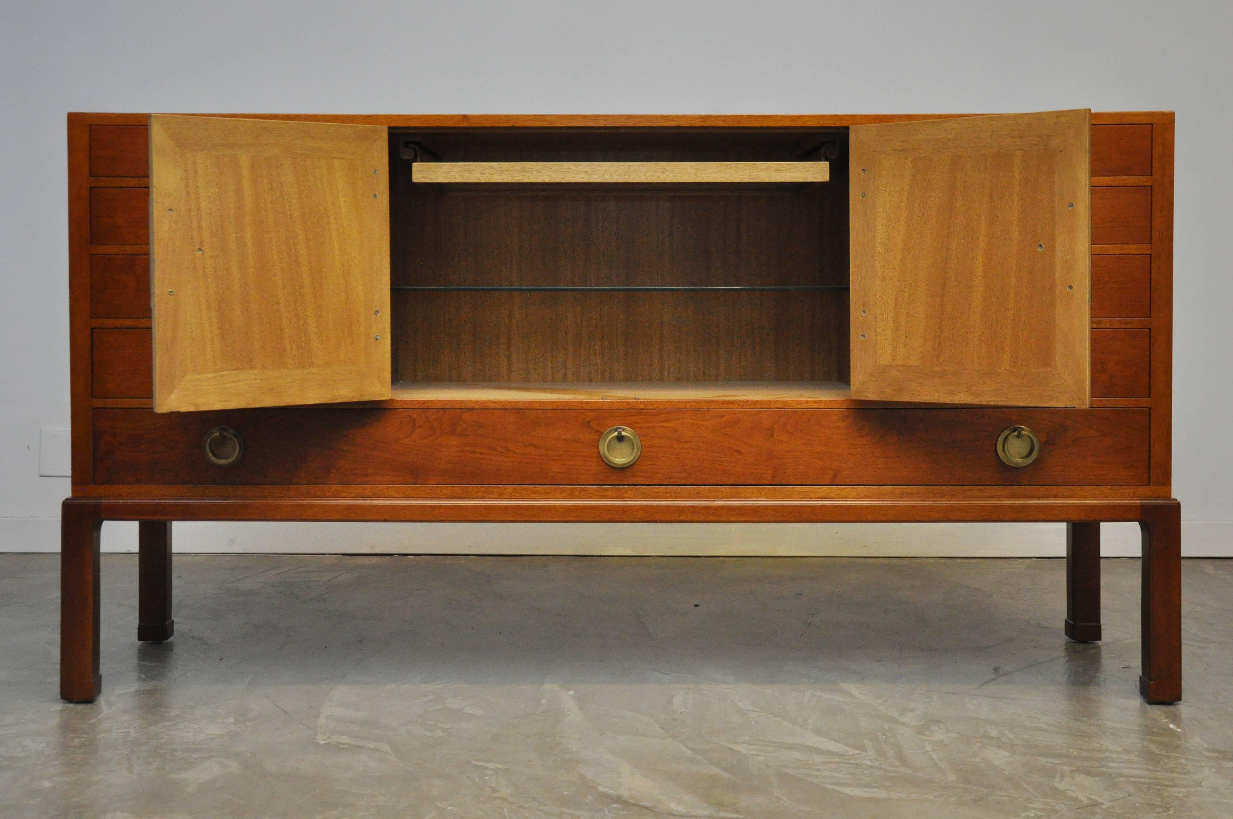 Beautiful sideboard designed by Edward Wormley for Dunbar in 1945, model 4579. The center compartment features an adjustable glass shelf and a removable glass-bottom tray.
