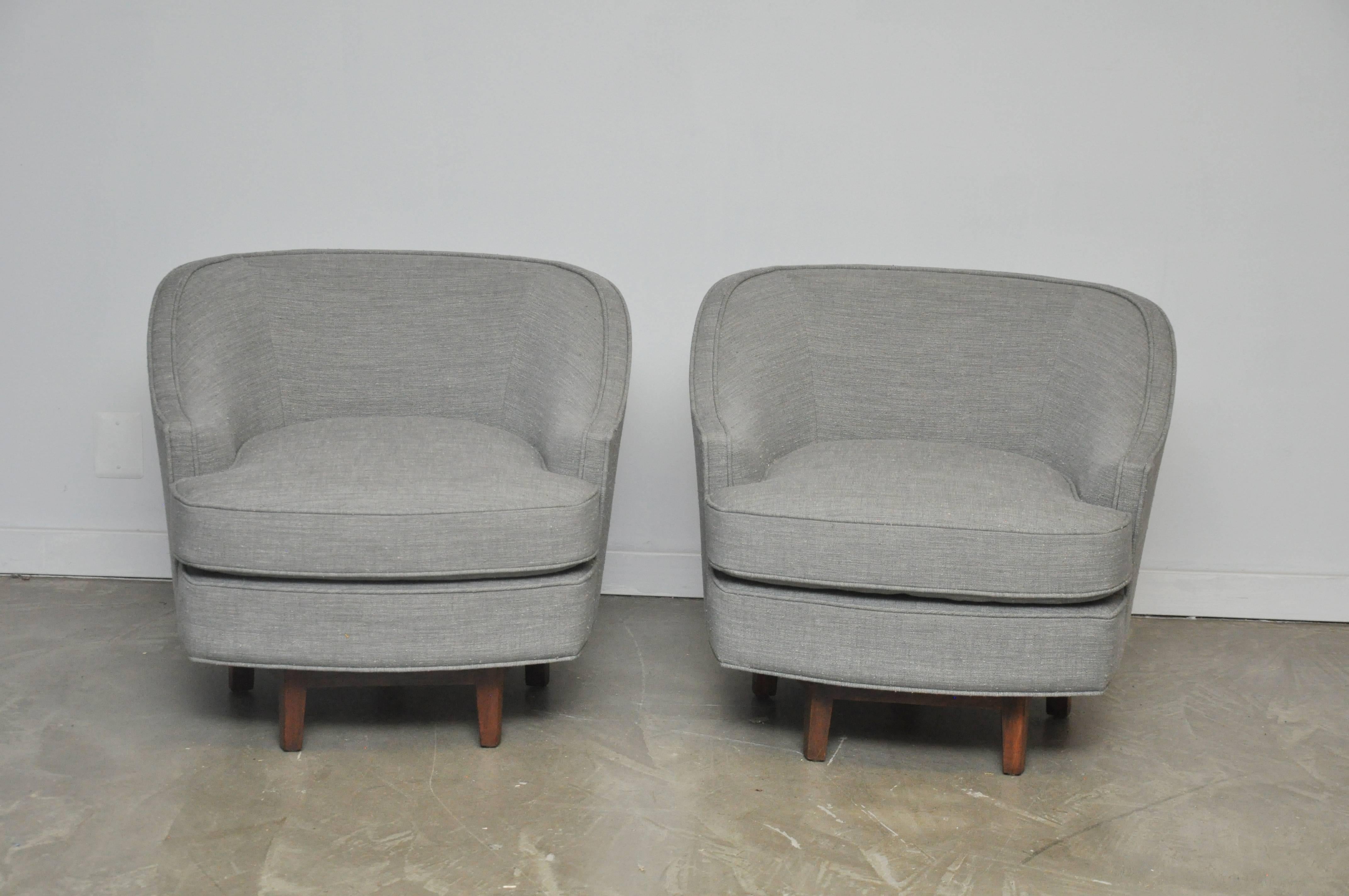 Pair of Dunbar swivel chairs on walnut bases. Fully restored and reupholstered in grey tweed.