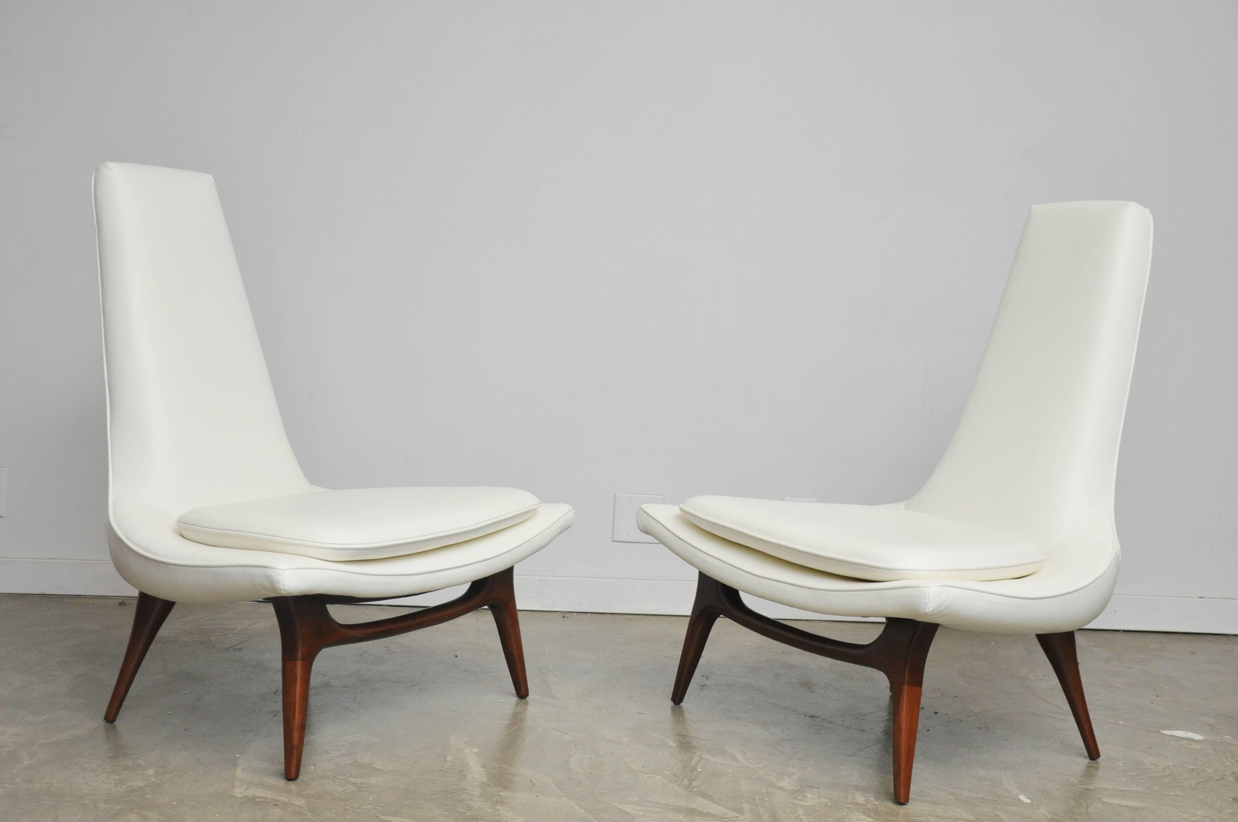 Pair of high back lounge chairs by Karpen of Ca. New leather upholstery over refinished legs.