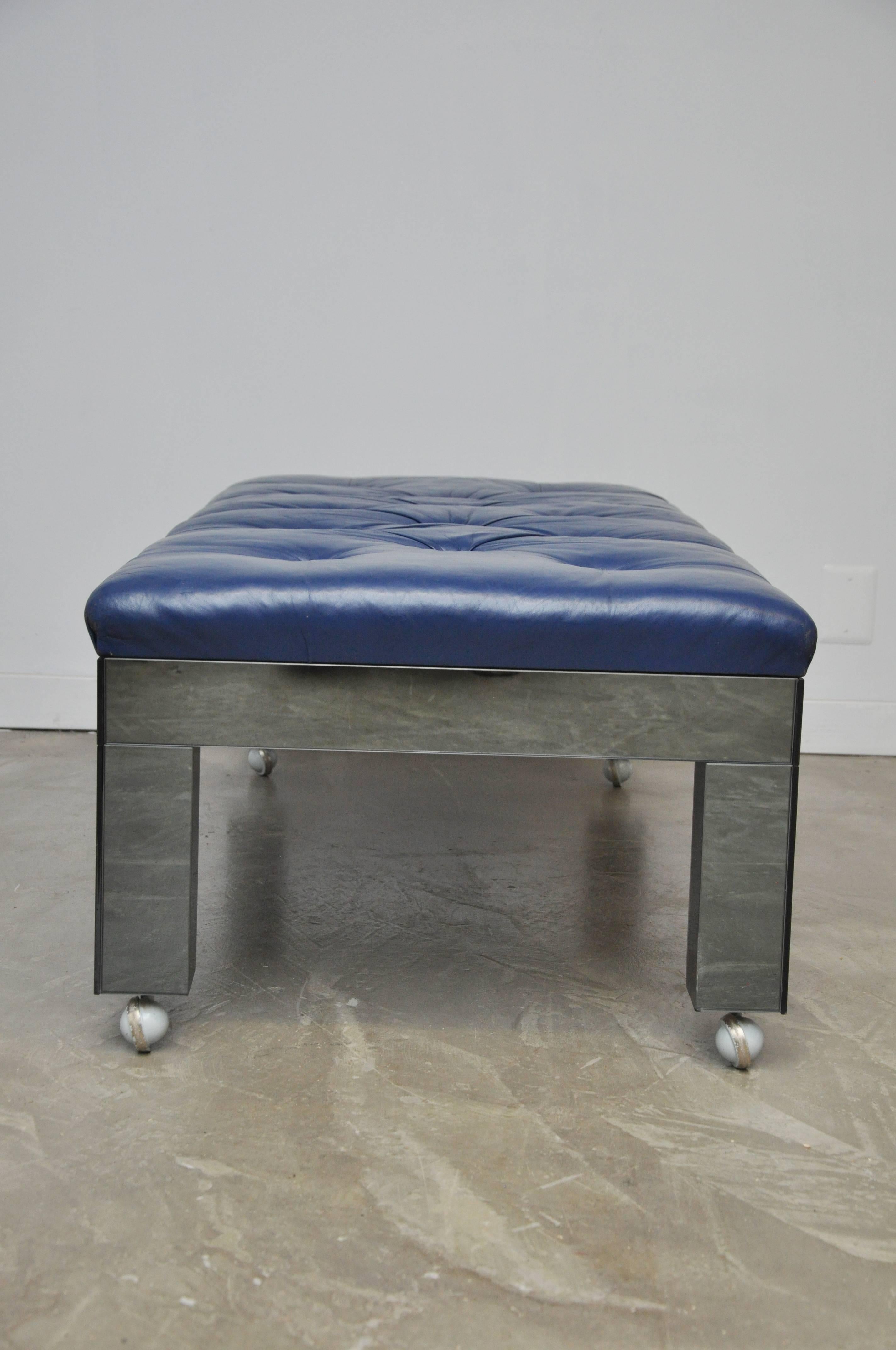 Beautiful mirror clad bench with original blue tufted leather. On castors for easy mobility, circa 1970s.