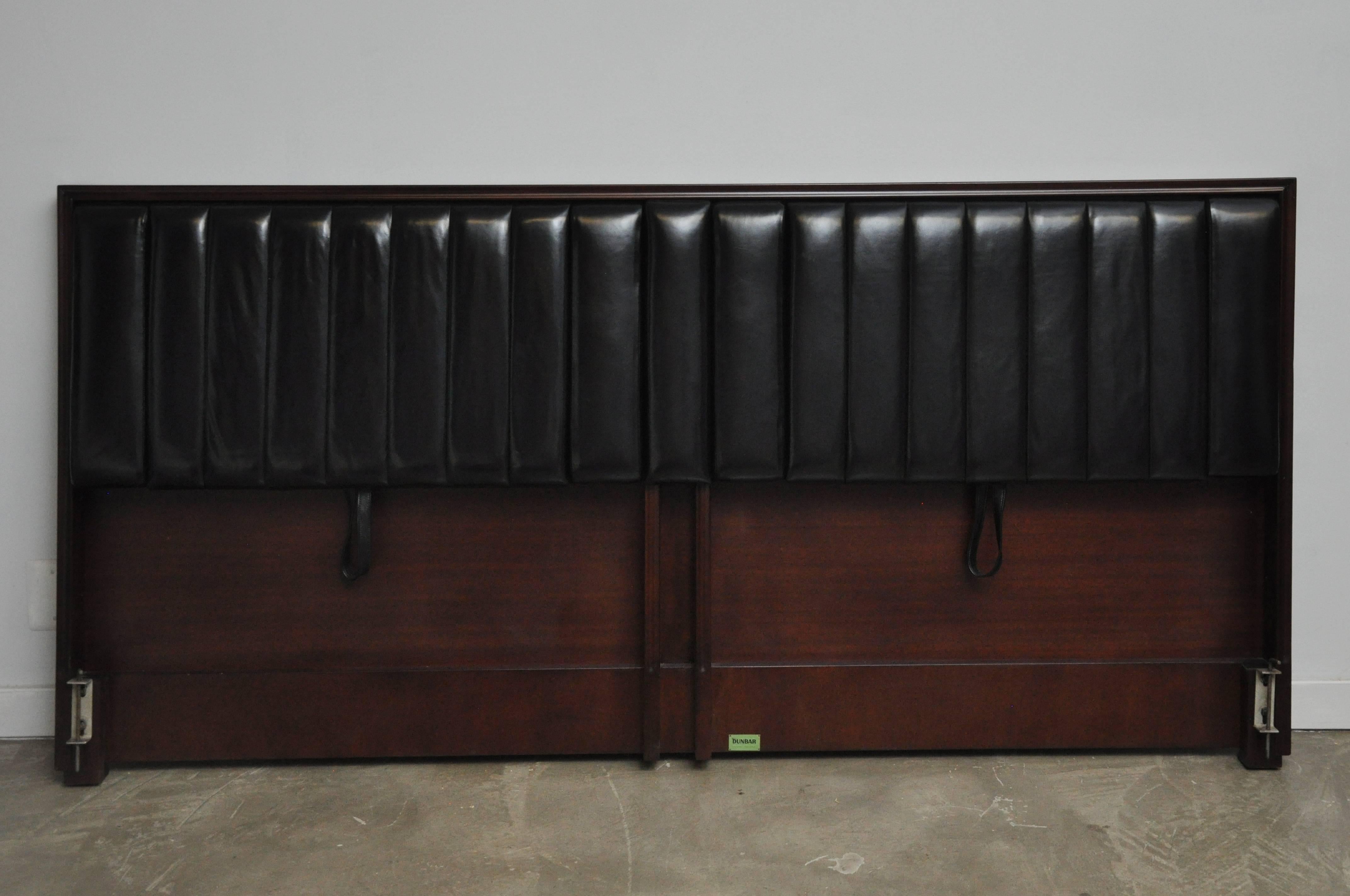 Adjustable king-size headboard by Edward Wormley for Dunbar. Model 4588, circa 1950s. Both sides have drop down arms and adjustable back. Restored mahogany frame in walnut finish with black leather upholstery.
