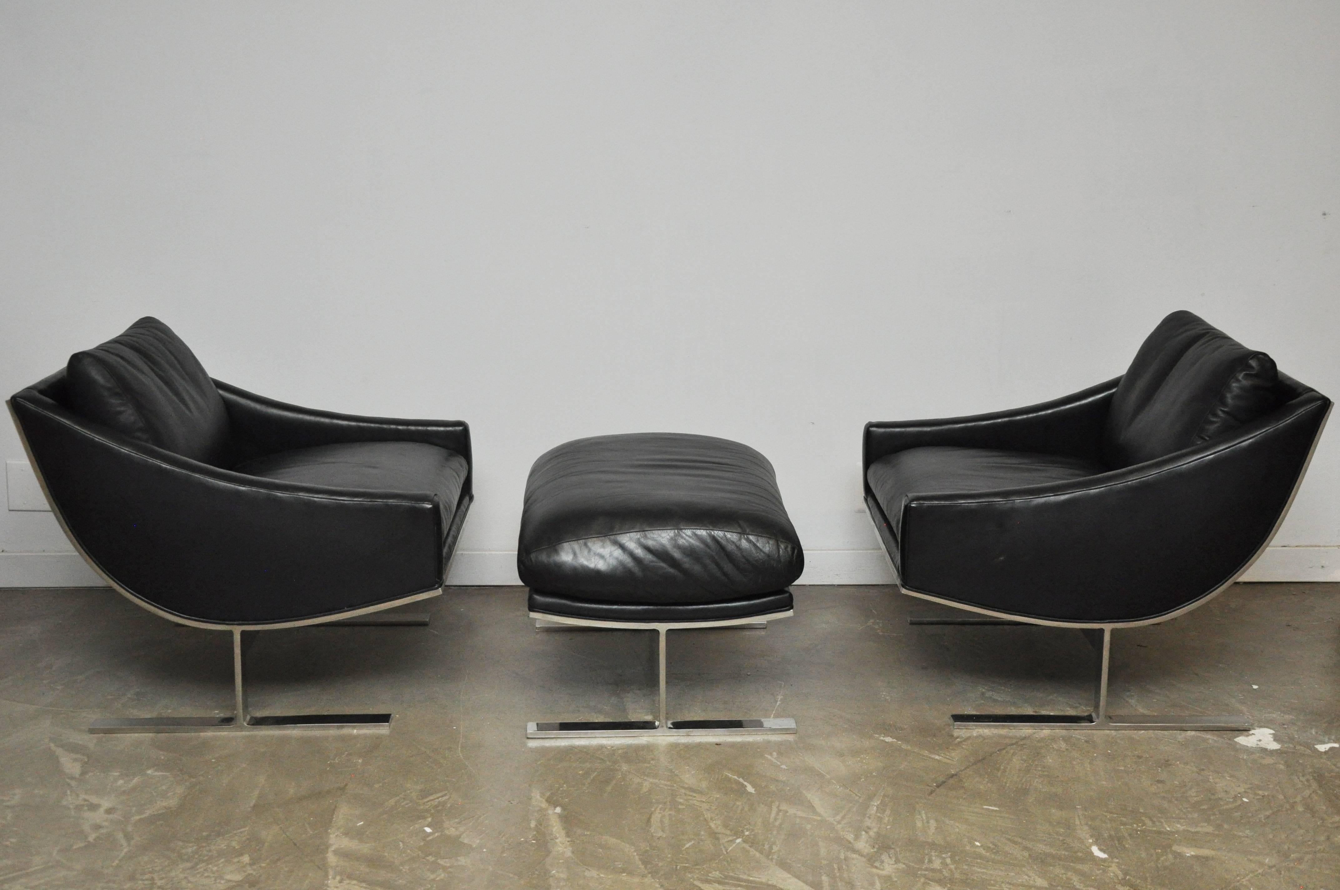 Rare pair of Arc lounge chairs with one shared ottoman. Polished stainless steel with original black leather.