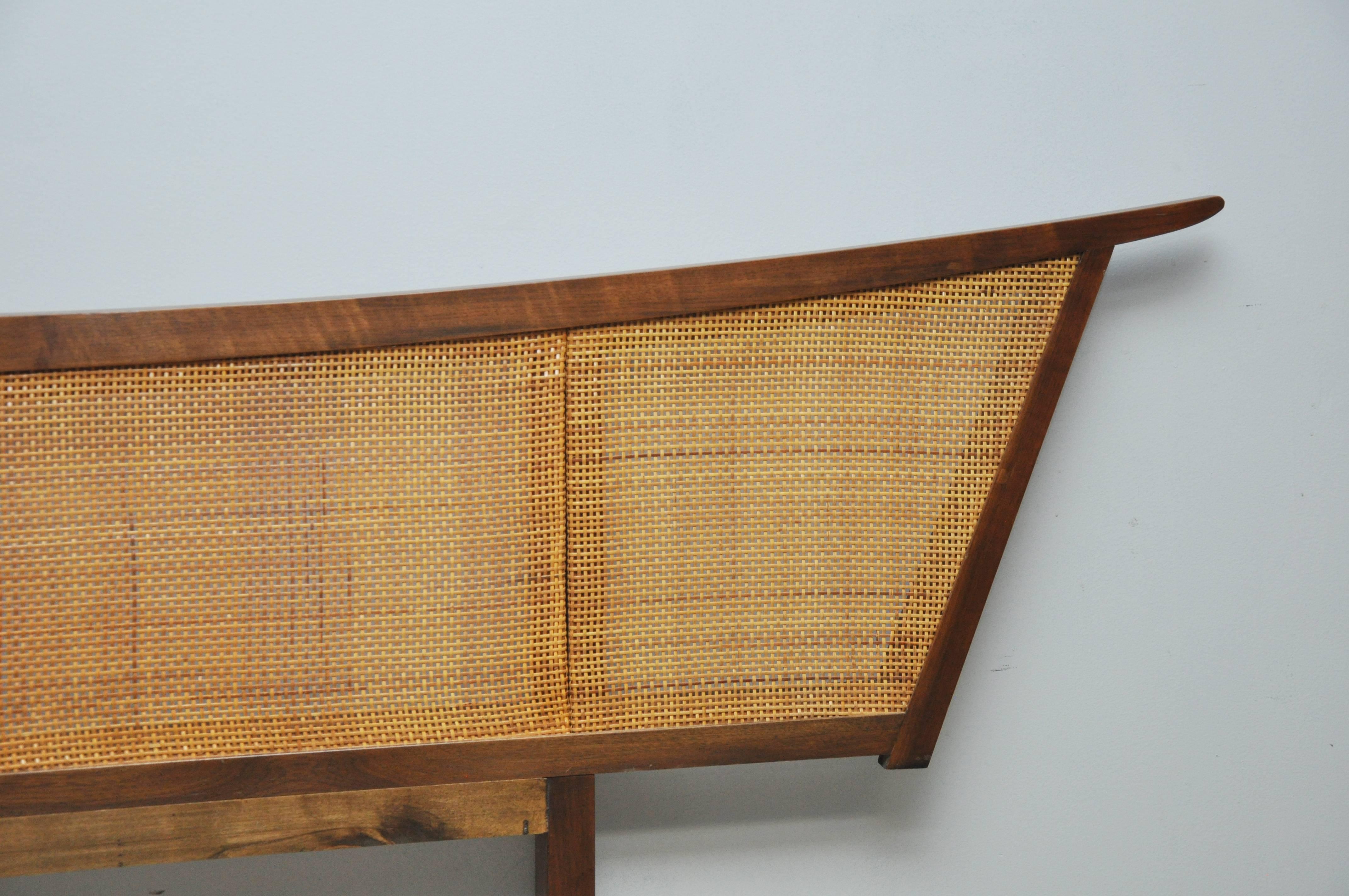 We are proud to offer this king-size walnut and cane headboard by George Nakashima for Widdicombe Furniture. Exaggerated form from the "Origins" line.