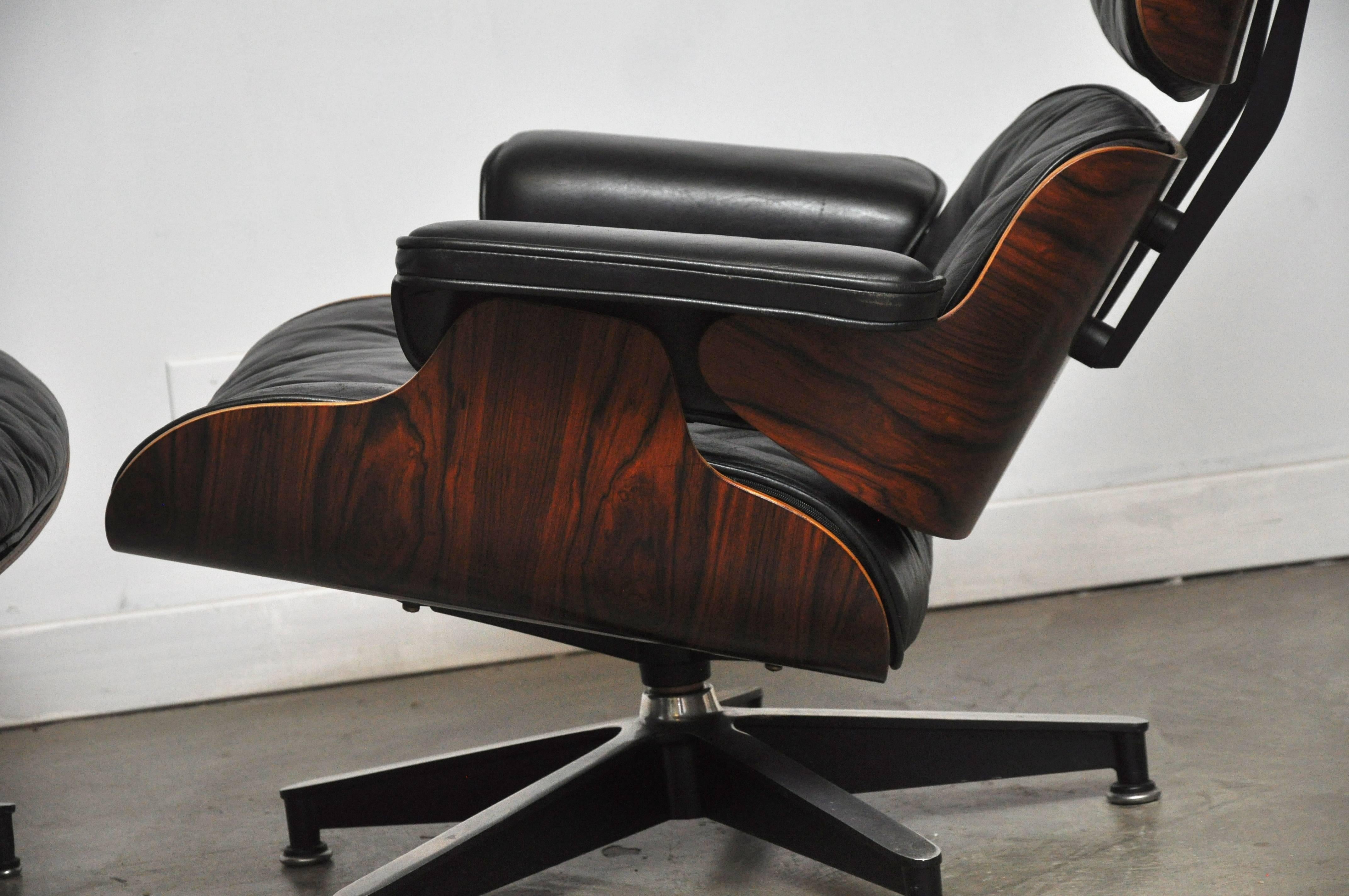 Early model 670 rosewood lounge chair and 671 ottoman designed by Charles and Ray Eames for Herman Miller. Original black leather and refinished rosewood shells, circa early 1960s. Down cushions, rubber headrest shock mounts.