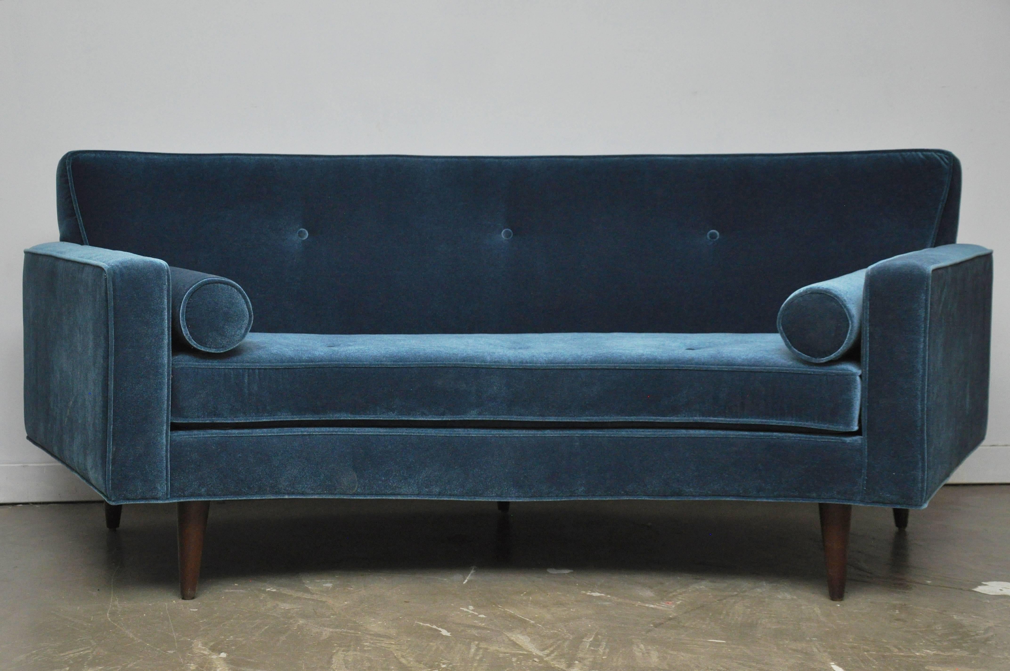 Curved settee by Harvey Probber. Fully restored and reupholstered. A beautiful form in blue, with bolster pillows at each end.
