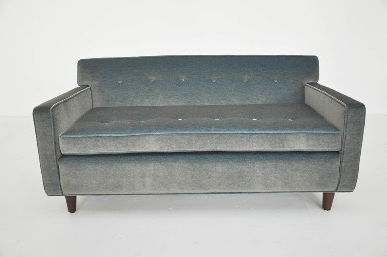 Pair of settees designed by Edward Wormley for Dunbar.  Newly upholstered blue-grey mohair over refinished walnut legs.