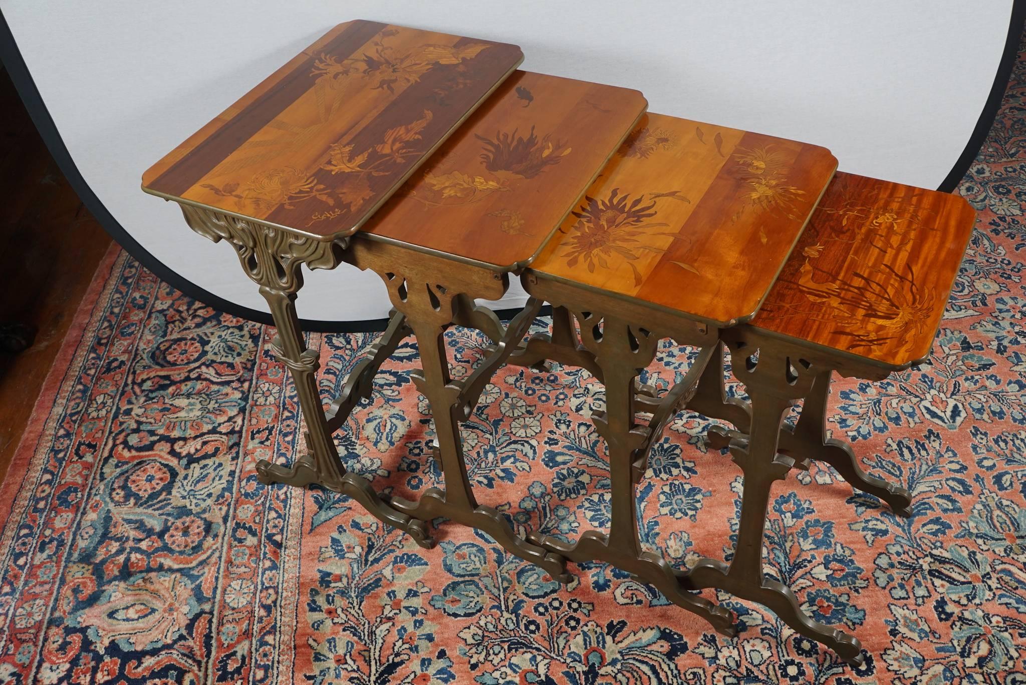 Fine set of French Art Nouveau inlaid nesting tables by Emil Gallé. Four graduated walnut tables with fruitwood marquetry. On carved faux-bronzed legs united by stretchers with down turned feet. 
Signed in inlay: 