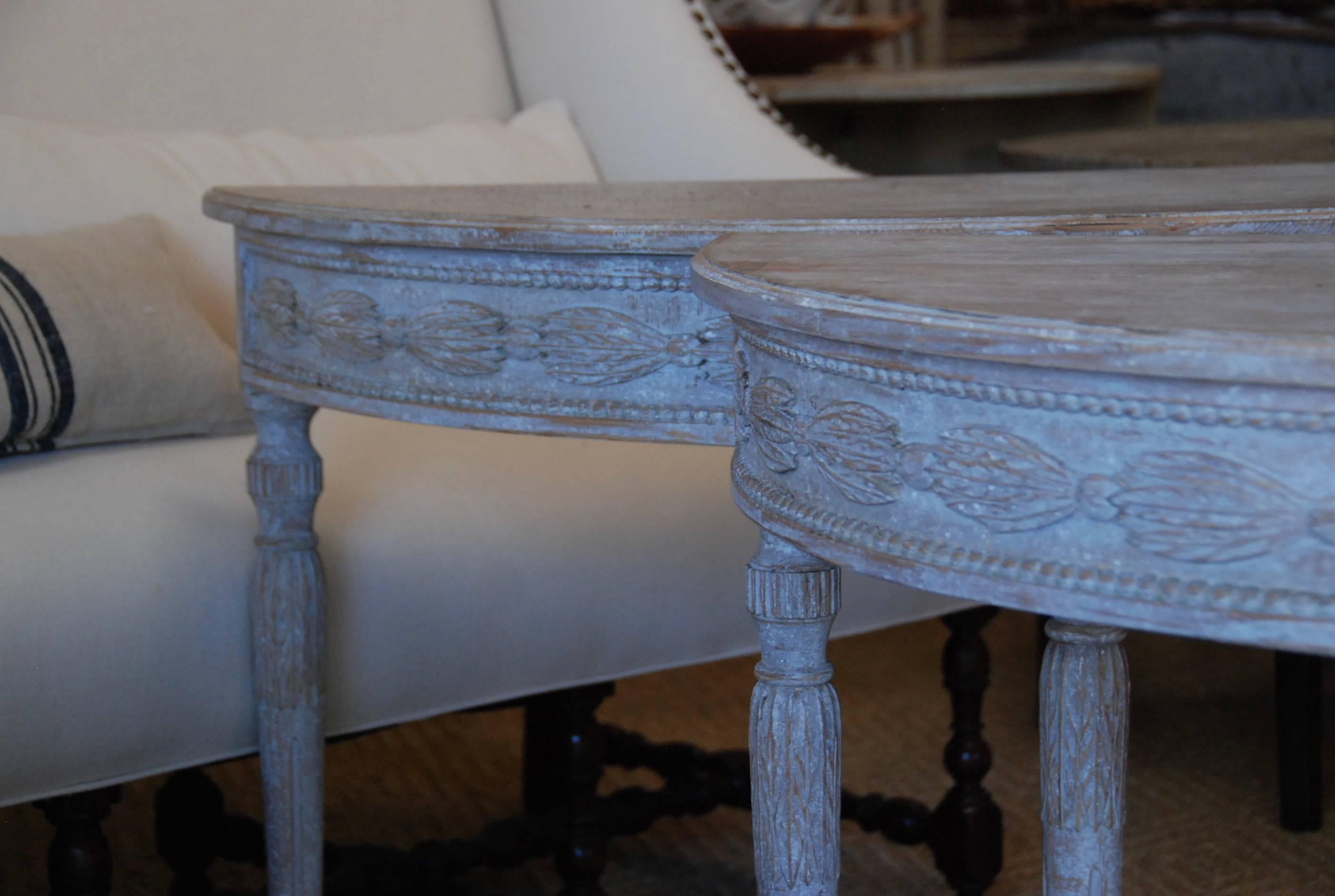 Elegant pair of demilune console tables with beautifully carved apron over lovely tapered fluted legs. Very Pretty. Stockholm, Sweden.