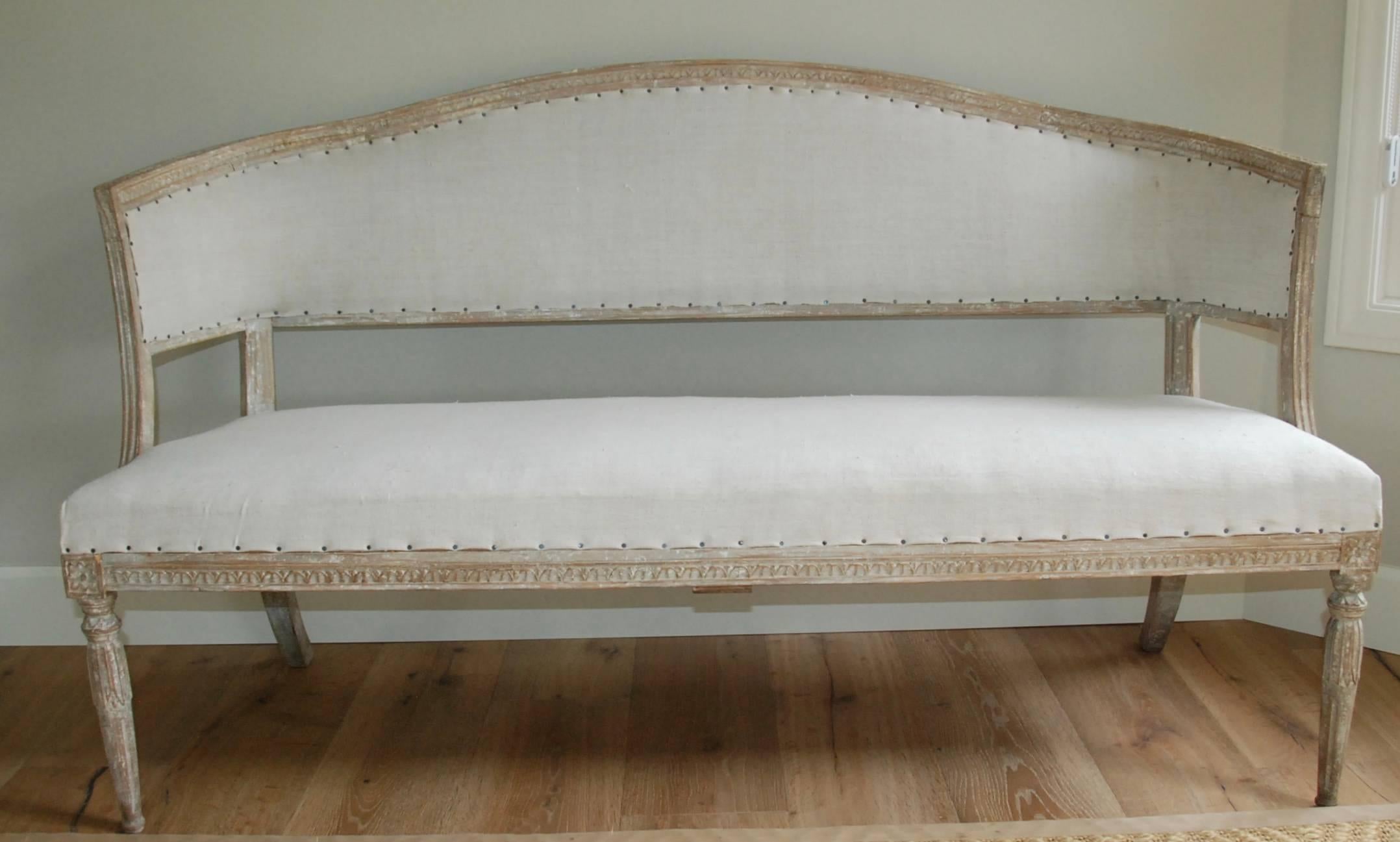 Elegant Gustavian style barrel back sofa in scraped down cream white color. Lovely tapered carved legs and arms. Extra detail of beautiful carving along top crest of sofa, as seen in photos.