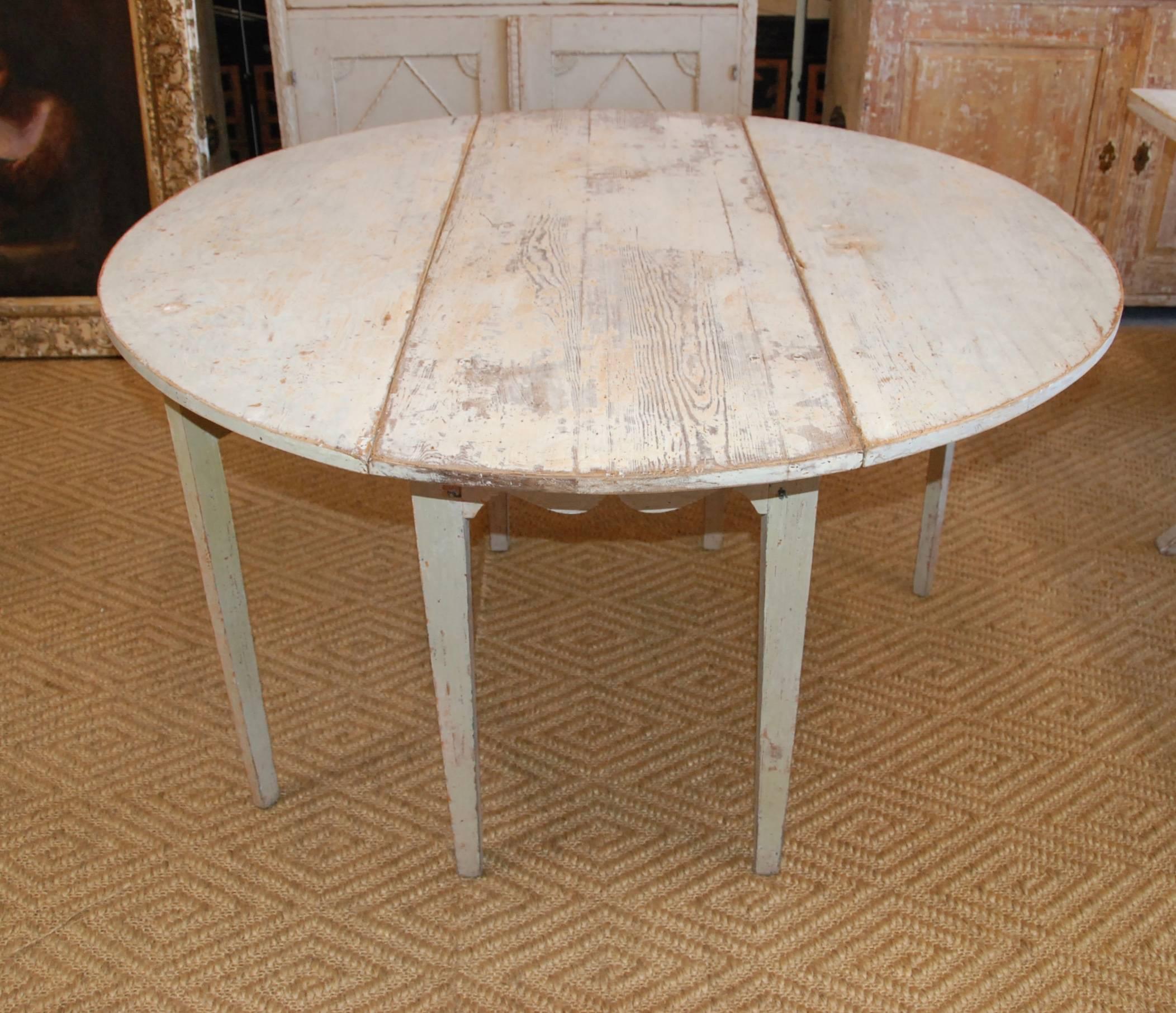 Early 19th century, Swedish drop-leaf table with original worn paint patina. The top is a lovely aged pine and the base is a pale Swedish green/blue. Closed the table measures 18