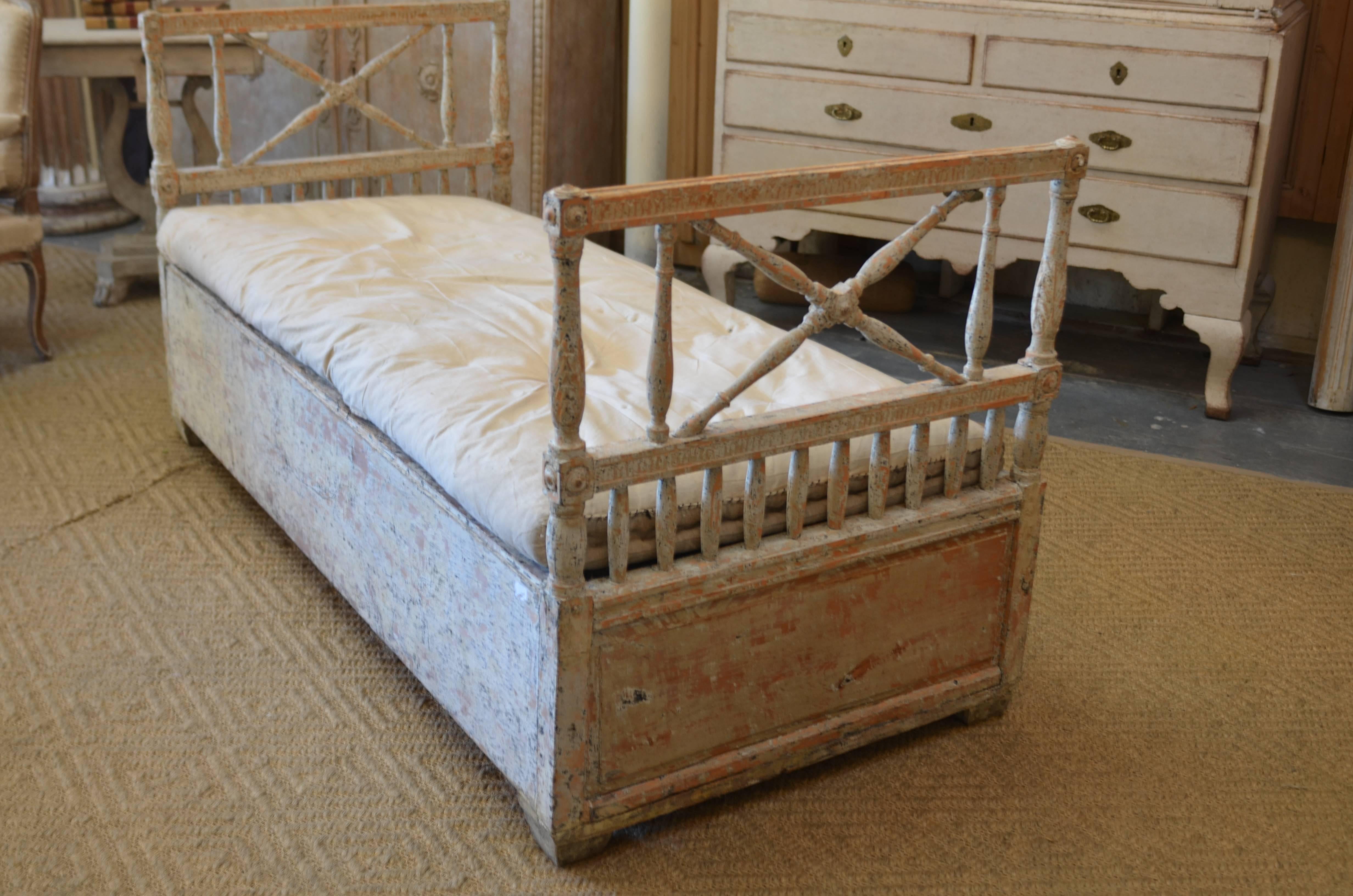 Beautiful 18th century swedish daybed/bench. Lovely hand carving on the the head and foot board. Original hand scraped paint in a Swedish cream/white color. Terrific size for lounging in front of a fireplace, end of a bed or tucked into a private
