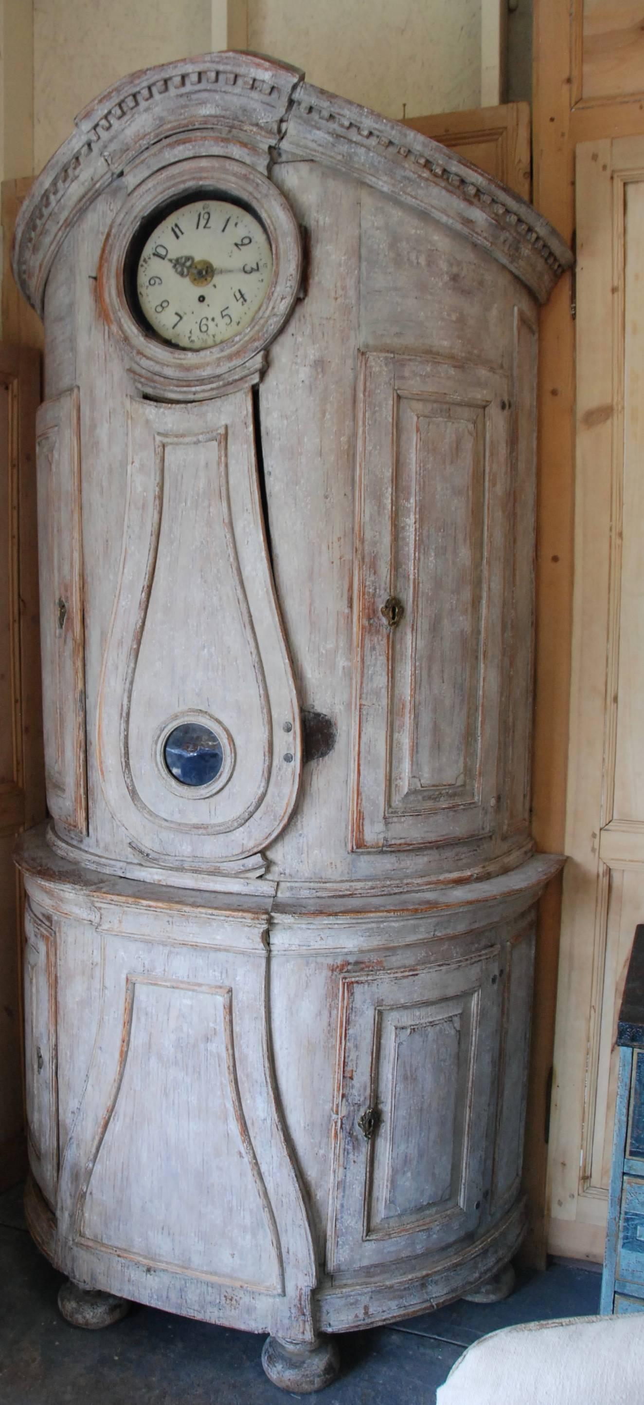 Beautiful 18th Century Swedish Demi lune Clock Cupboard. Four raised paneled cupboard doors open to lovely storage on the sides. Dental carving on the cornice apron with elegant paneled clock detail in the center. All Scraped down to original