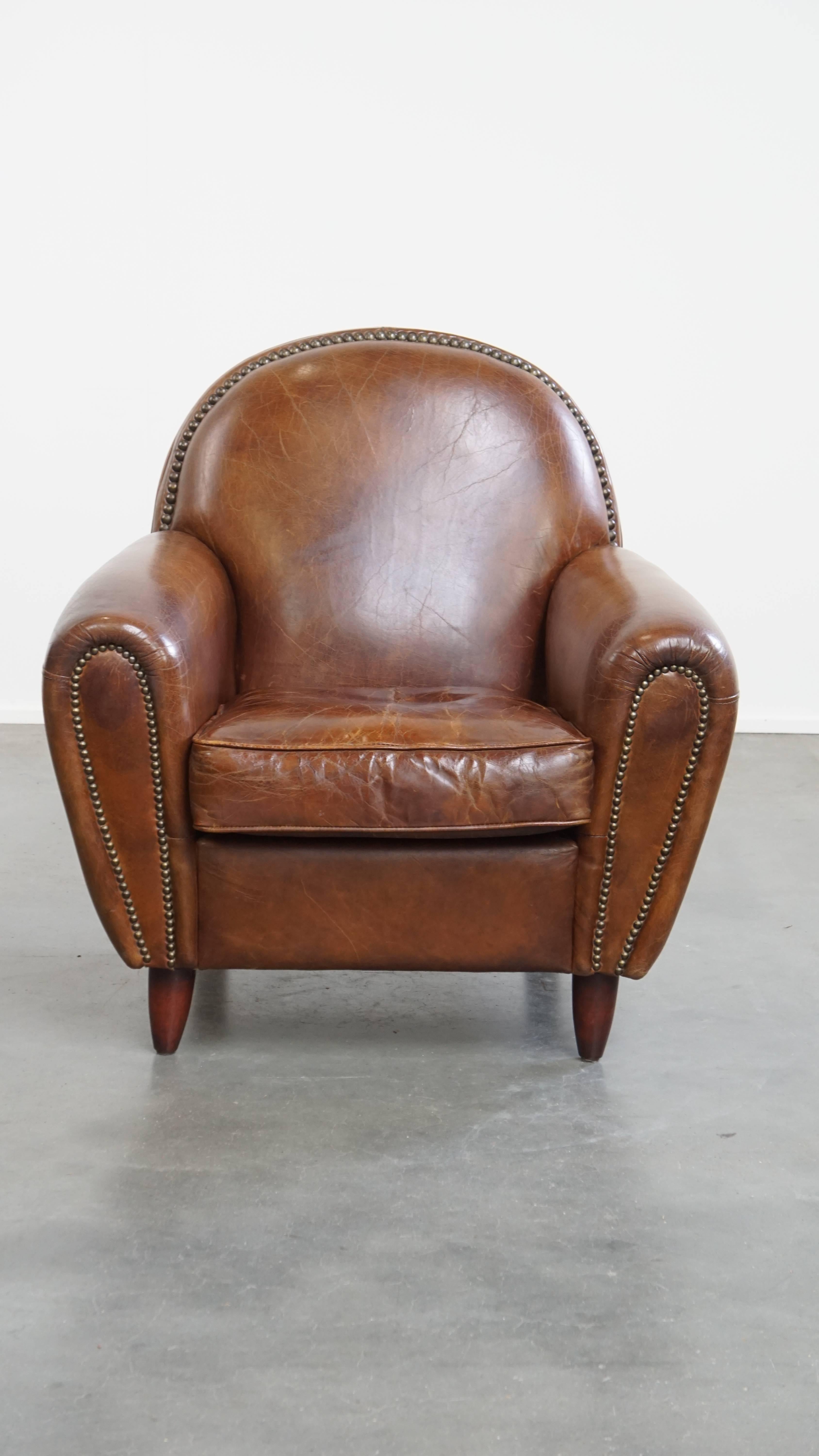 Ce magnifique fauteuil en cuir de vachette présente de belles formes rondes avec des détails raffinés et des clous décoratifs. Il peut être facilement placé dans des intérieurs classiques et modernes dans la pièce de votre choix. Il est revêtu de
