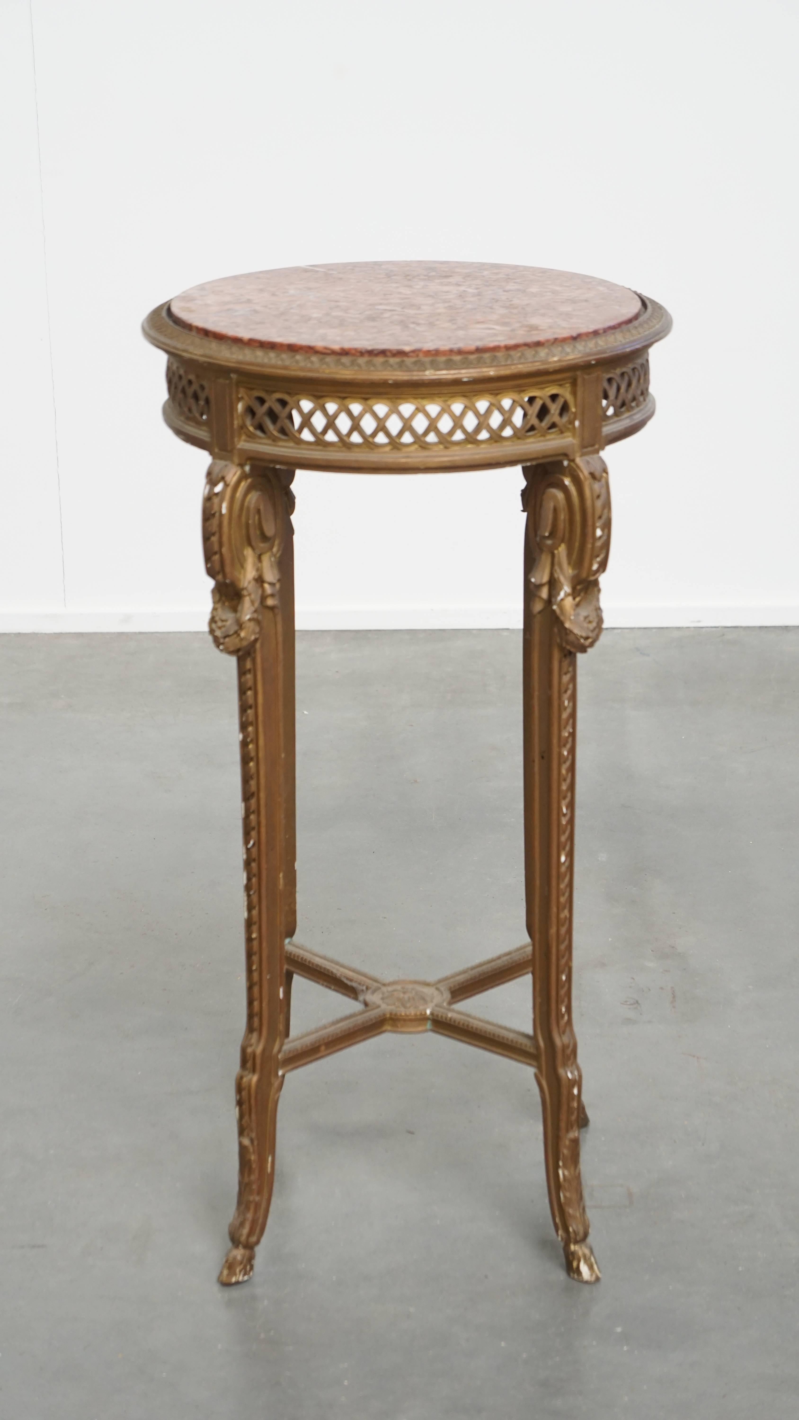 Cette table d'appoint ronde et ancienne est très belle. Il se compose d'un cadre en bois avec de belles sculptures et d'un superbe plateau en marbre coloré. Cette table s'intègre bien dans presque tous les intérieurs de la pièce de votre choix. Au