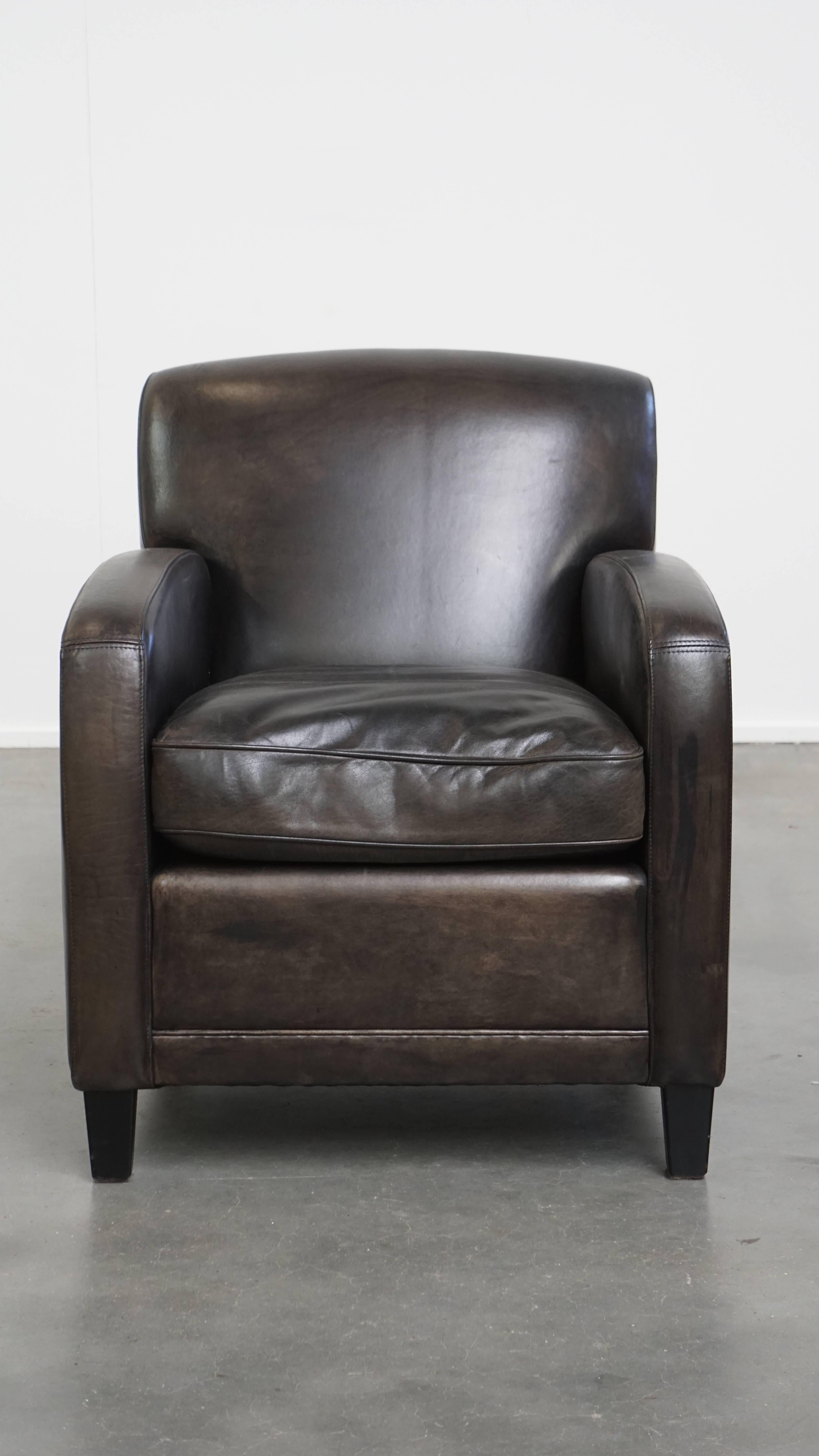 Ce fauteuil noir en cuir de mouton, avec son beau design et son aspect intemporel, trouve facilement sa place dans presque tous les intérieurs. Il est doté d'un coussin d'assise amovible et offre un confort d'assise fin et correct. En raison des