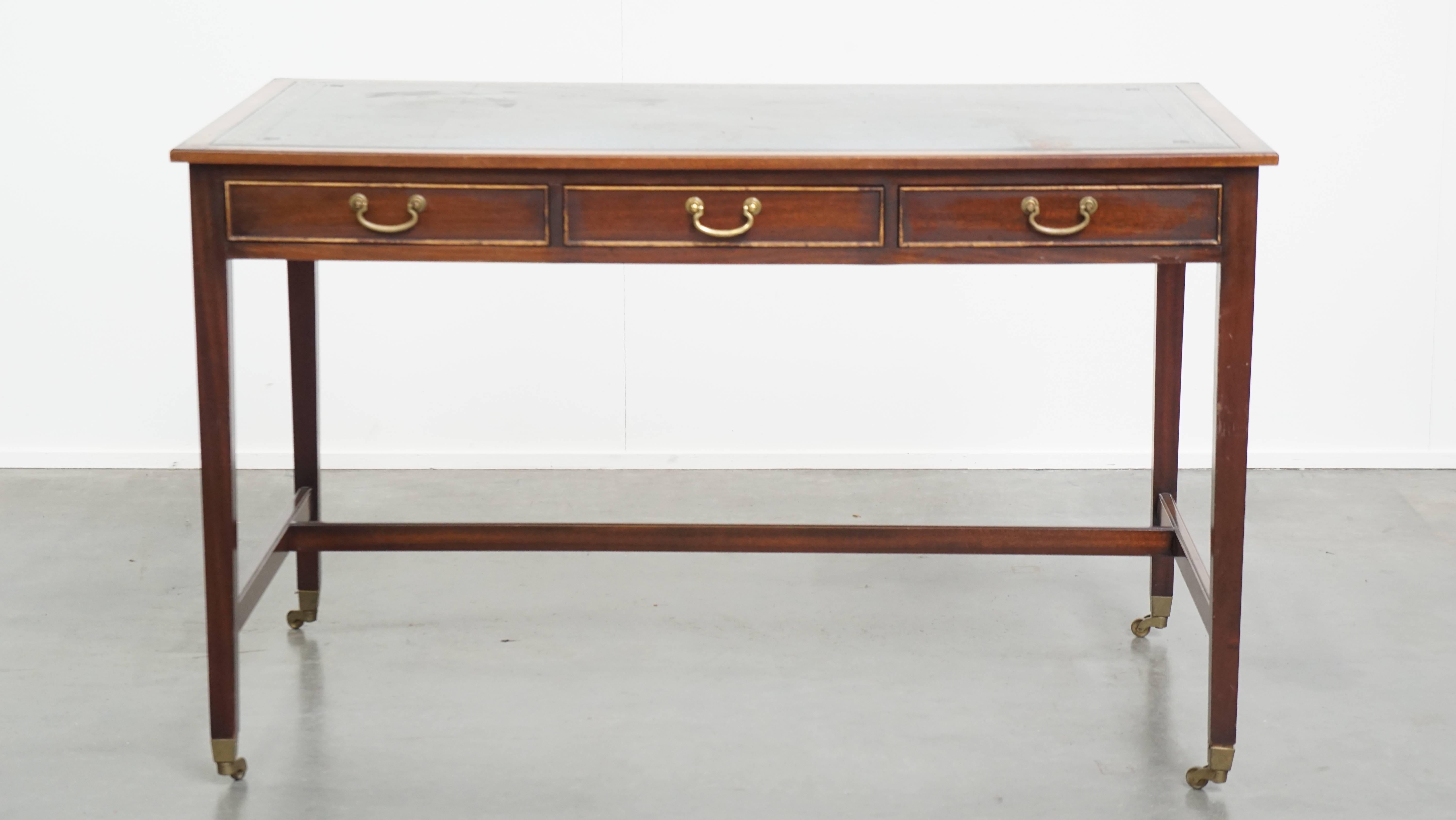 This great classic writing desk in English style is a perfect timeless addition to almost any interior in the room of your choice. The desk has a blue leather top and stands on wheels, making it easy to move. It is equipped with three drawers,