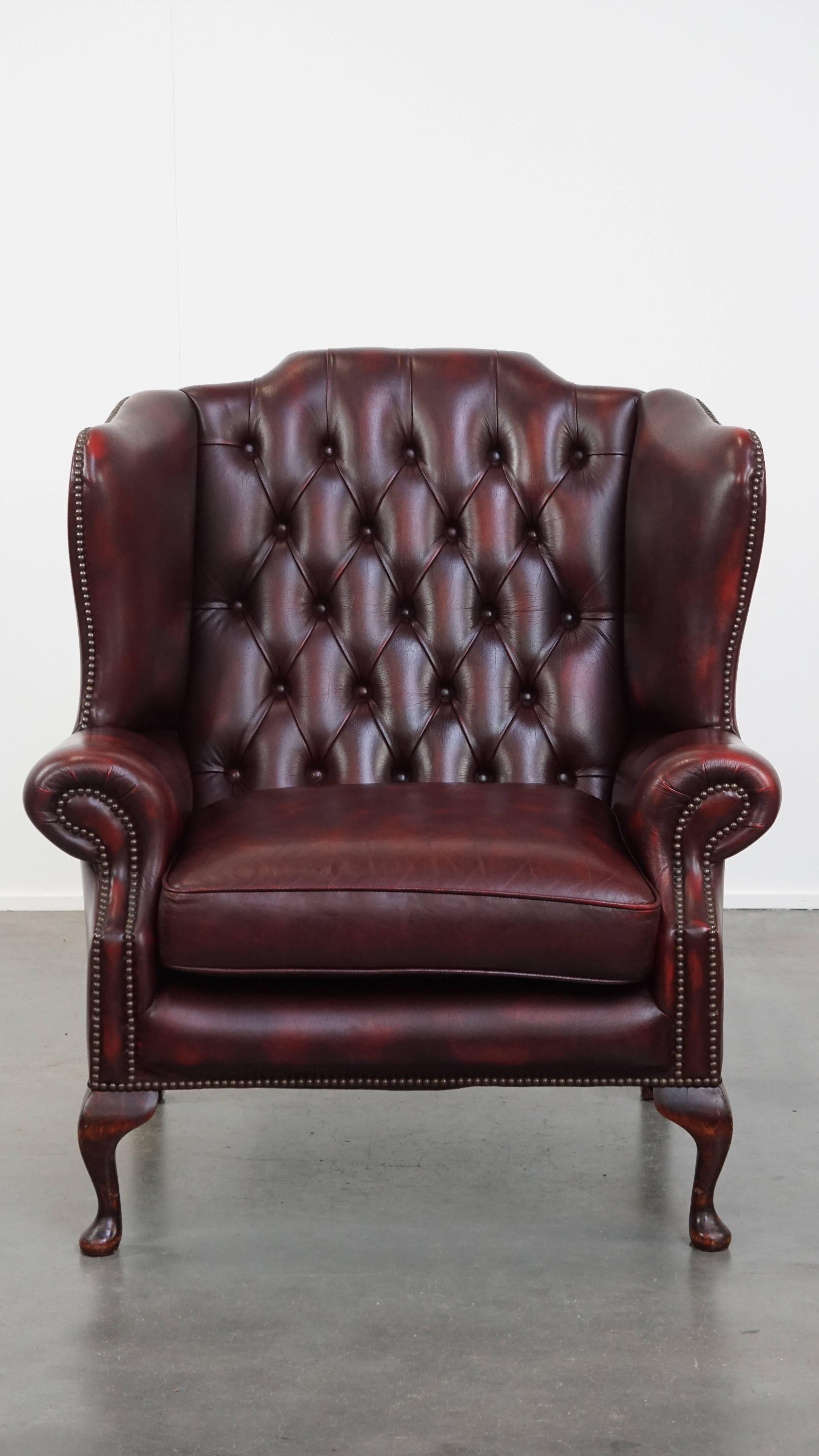 Angeboten wird hier ein klassischer englischer Chesterfield-Sessel aus rotem Rindsleder mit einer außergewöhnlich breiten Sitzfläche. Dieser lederne Ohrensessel ist die perfekte Ergänzung für Liebhaber von Chesterfield-Möbeln. Seine atemberaubende