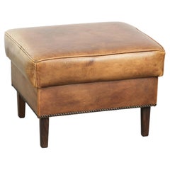 Pouf in pelle di vacchetta con una splendida patina e rifinito con chiodini decorativi