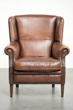 Subtle dark brown sheepskin wingback armchair with a timeless look subtle