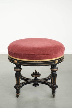 Antique English stool with a red fabric seat and a black wooden base