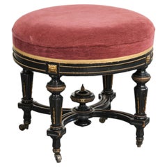 Antique English stool with a red fabric seat and a black wooden base