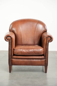This vintage sheepskin armchair offers comfortable seating and is finished with