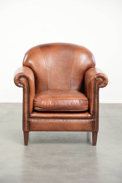 Comfortable vintage sheepskin armchair finished with decorative nails