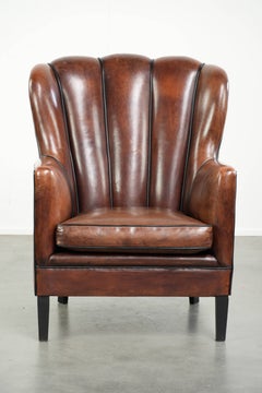 Comfortable sheepskin armchair in unique design finished with black piping