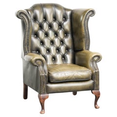 Characterful green cow leather Chesterfield wingback armchair in English style