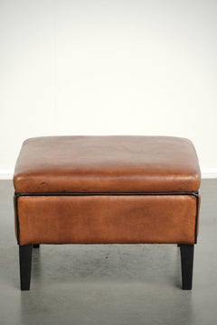 Versatile sheepskin ottoman/footstool in a warm cognac colour