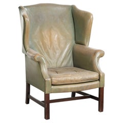 Old cow leather wingback armchair in English style with beautiful patina