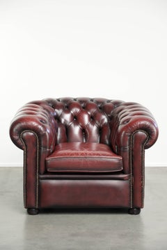 Chic lived-in English chesterfield club armchair in a timeless red colour