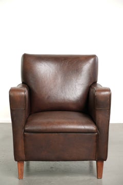 Subtle dark vintage sheepskin armchair with fixed seat cushion and timeless desi