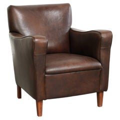 Subtle dark vintage sheepskin armchair with fixed seat cushion and timeless desi