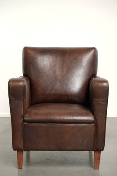 Fauteuil vintage robuste en peau de mouton, au design anglais intemporel