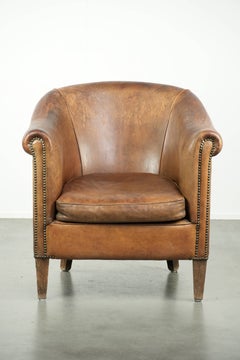 Vintage sheepskin club armchair finished with decorative nails