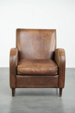 Set of a sheepskin armchair and ottoman finished with matching piping