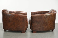 Set of 2 cowhide Aviator design armchairs in a warm brown colour