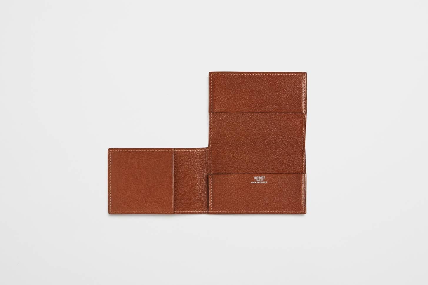 A hand-stitched pig skin card wallet. The piece is a classic opening card wallet. It folds into a practical card case style shape, but opens up into a larger L-shape for carrying additional items. The wallet opens up to have spaces two spaces for