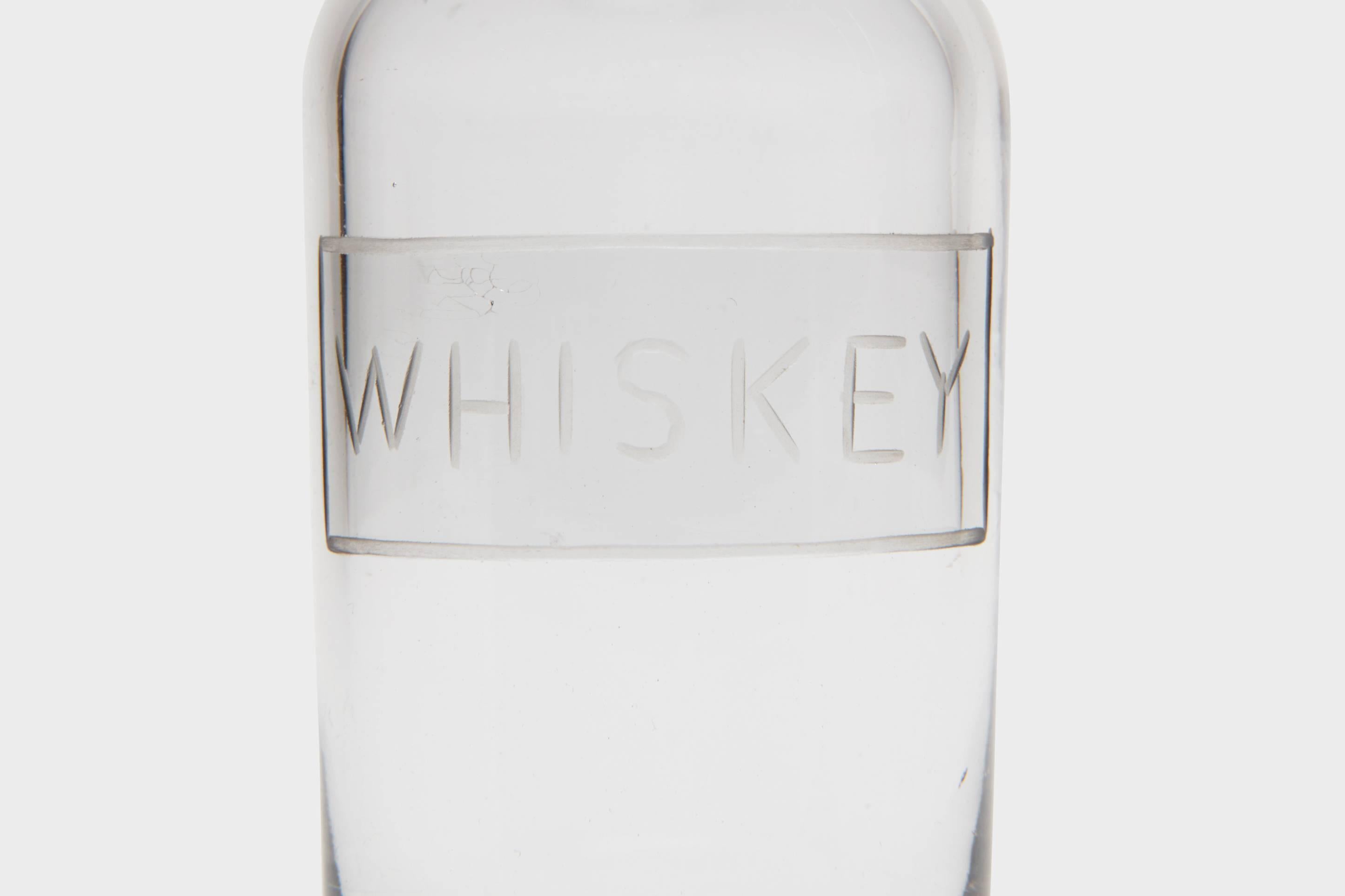 A sterling silver and handblown glass miniature 'Whiskey' bottle. This novelty piece of barware can have a myriad of functions, not all of which need limiting to the home bar.
Aside from decanting a small serving of your favourite whiskey, there is