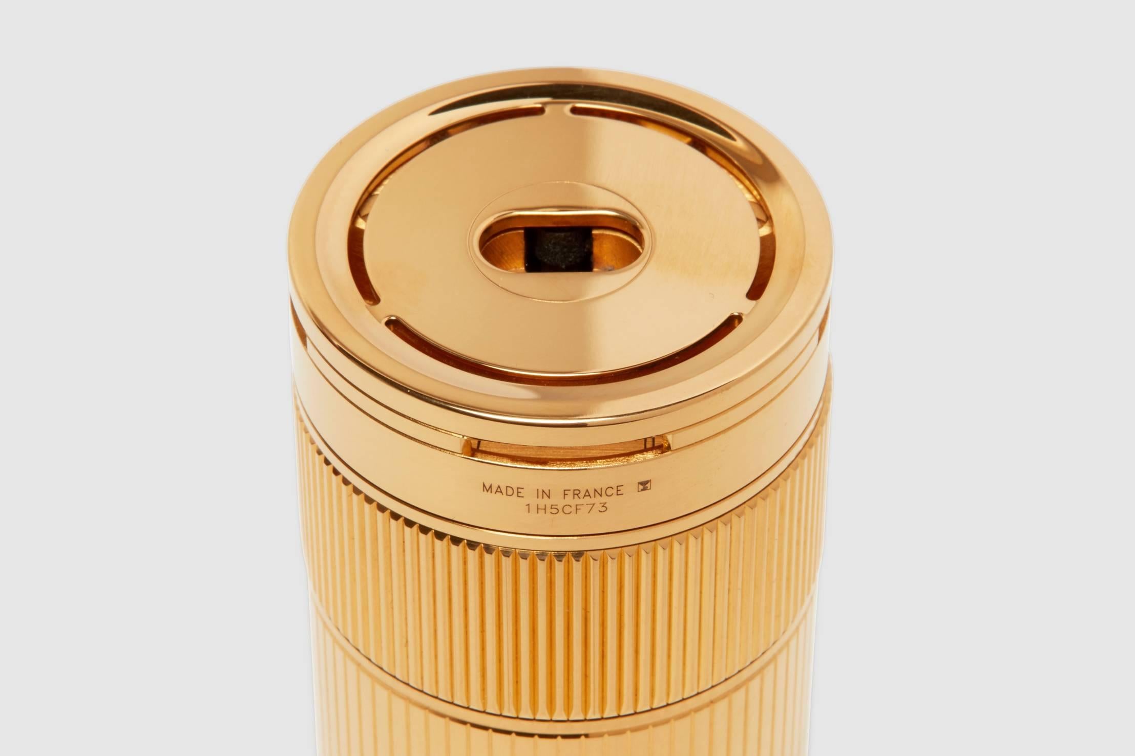 A gold-plated S. T. Dupont cylinder model table lighter. This is one of the finest lighters that money can buy. It is beautiful in design, exceptional in make, and has an ingenious sparking mechanism.

The finely ribbed neck element is turned to